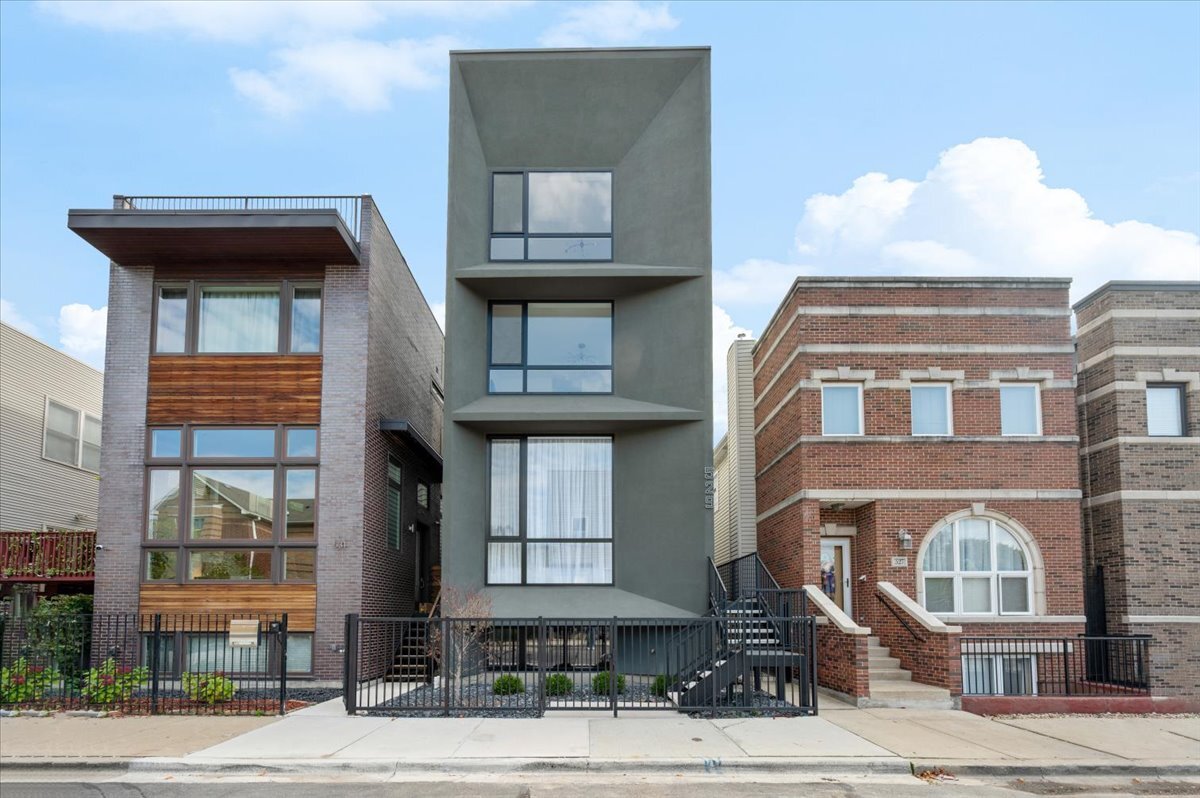 This stunning new construction custom home is truly one-of-a-kind-not just on its block, but across the entire neighborhood. Featuring a striking exterior design that looks as if it belongs on the pages of an architectural design magazine, this home immediately stands apart. Its most rare feature is a full third floor with a private rooftop deck and breathtaking Chicago skyline views, a distinction no other home nearby can claim.  Offering 4 bedrooms, 4.1 bathrooms, multiple outdoor spaces, and an attached 2-car garage pre-wired for EV charging, this home combines luxury sleek design, sophisticated finishes, and smart functionality for modern city living. Step inside to soaring 13-foot ceilings, sun-drenched interiors, and floor-to-ceiling windows that flood the open layout with natural light. Hardwood flooring flows throughout the home, while formal living and dining spaces create an elegant yet welcoming atmosphere.  At the heart of the main level is the chef's kitchen, complete with imported European cabinetry, quartz countertops, and top-of-the-line appliances. The living space extends seamlessly to the garage rooftop deck, perfect for entertaining or al fresco dining. The primary suite is your private retreat, featuring a spa-inspired bath with a steam shower, rain head, body sprays, and a dual vanity. Two additional bedrooms share a beautifully designed full bath with sleek tilework and tub/shower.  The top floor is a showstopper-boasting a spacious guest suite with an en-suite bath, a rec room with wet bar, laundry, and access to the rooftop oasis where skyline views set the perfect backdrop.The lower level offers even more flexibility with a large family or media room, a full bathroom, and a second laundry space. Located in the heart of West Town, you'll enjoy proximity to neighborhood favorites like Publican Bakery, Beatnik, Breakfast House, Forbidden Root, and countless boutiques, breweries, and coffee shops-with quick access to public transit and downtown Chicago.  This home is the ultimate blend of architectural beauty, functional design, and rare luxury in one of Chicago's most dynamic communities. New develope