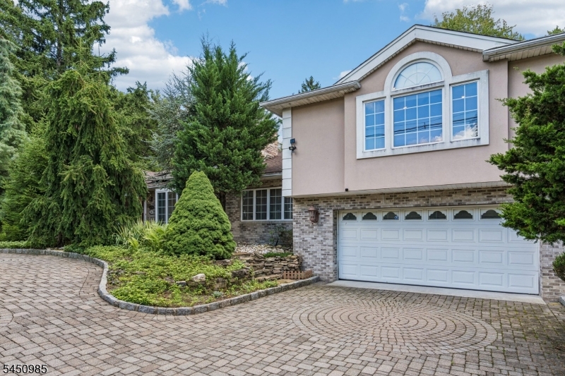 Tucked away behind a circular paver driveway and mature privacy trees, this one-of-a-kind custom expanded ranch offers exceptional space, style, and versatility. The open living and dining areas are anchored by a striking double-sided fireplace, while soaring ceilings and skylights fill the home with gorgeous natural light. Designed for both everyday living and effortless entertaining, the custom chef's kitchen offers abundant cabinetry, generous prep space, and seamless flow to the living room.The first floor features two bedrooms sharing a full hall bath, plus a private primary suite with a walk-in closet. And storage is truly exceptional throughout there's a place for everything. Upstairs, discover a spacious bonus living area with direct deck access, along with a second primary suite for added flexibility.The finished basement expands the possibilities even further with valuable recreation and living space, complemented by a French drain. Outside, a huge rear deck overlooks the expansive backyard, creating the perfect setting for summer gatherings and quiet afternoons alike. A two-car attached garage completes this truly special property. This home offers the rare combination of privacy, space, and easy access to shopping, dining, major transportation, and everything Wayne has to offer.