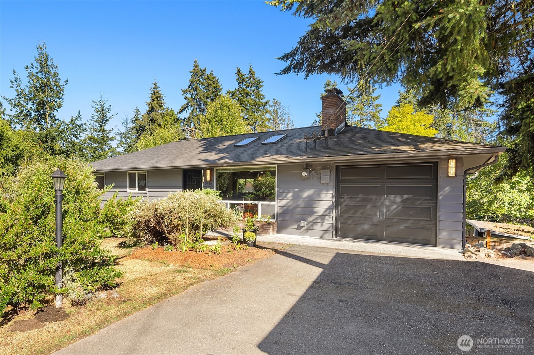 Set on a spacious, tree-lined corner lot in Edmonds, this fully renovated daylight rambler combines a practical layout with clean, modern finishes. The main floor features a bright living room that connects seamlessly to a custom kitchen with stainless steel appliances, quartzite countertops, tile floors, and custom cabinetry. Right off the dining space, a spacious deck looks out over the back yard, while three bedrooms and a fully updated custom bath complete the upper level. Downstairs, the finished daylight basement opens up the living space with two large recreation rooms, a built-in wet bar, and a direct walkout to the lower patio. Two additional bedrooms, a custom three-quarter bath, and a dedicated laundry space anchor this floor. Key upgrades include a newer roof, new garage door, newer paint and updated windows throughout the home. Step into the backyard with mature fruit trees and a gardener’s paradise. The grounds offer natural privacy while keeping you closely connected to the community. The home sits just blocks from local schools and parks, with quick, easy access to nearby shopping and I-5.