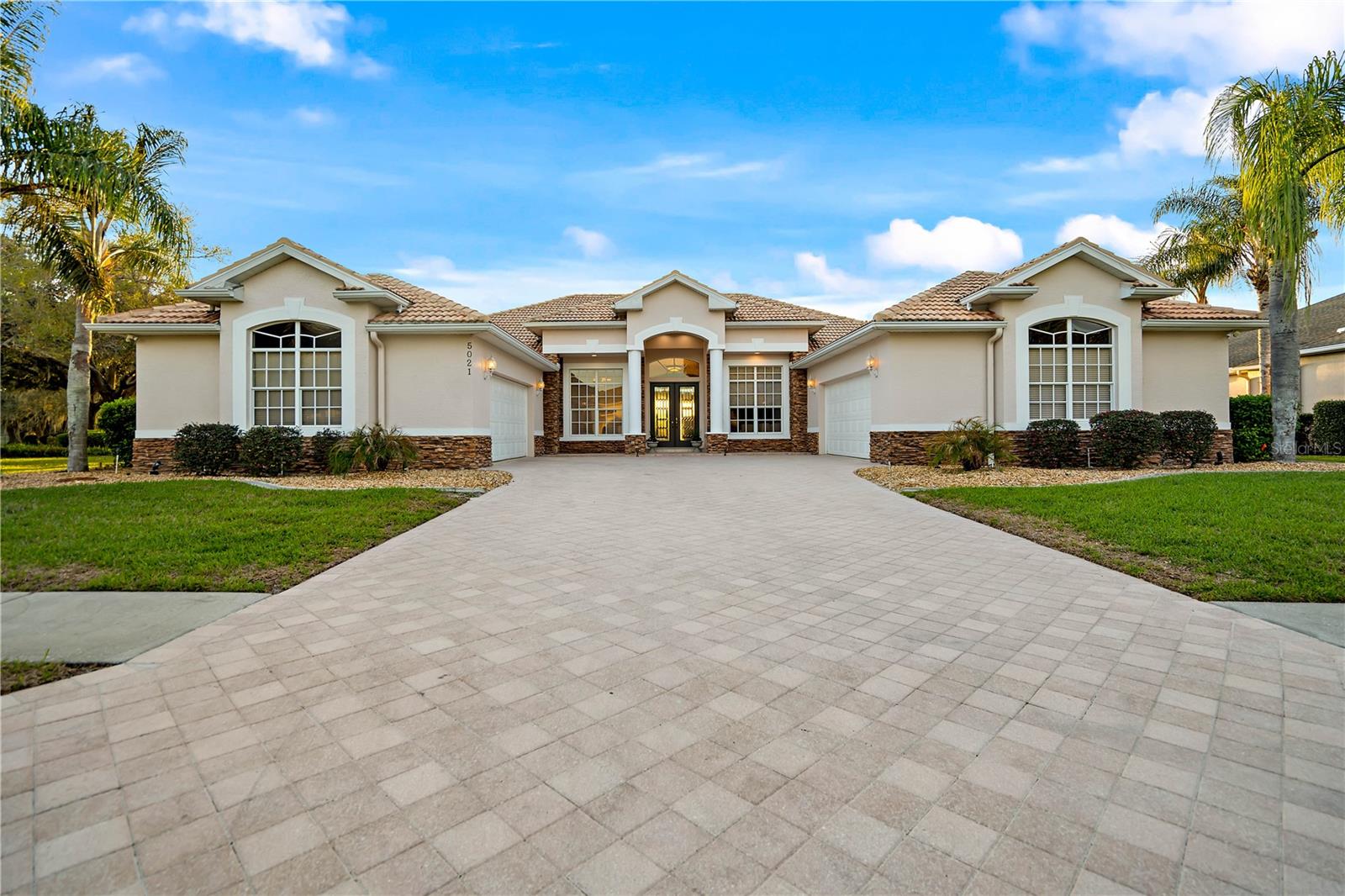 This home is both unique and stunning. A class act built and designed with quality. So If you’ve been looking for a GOLF COURSE HOME, this one right here is definitely worth a look. Sitting right on the 18TH HOLE in Silverthorn, this 5 BEDROOM, 4 BATH home gives you BEAUTIFUL SUNSET AND WATER VIEWS straight over your PRIVATE HEATED GUNNITE POOL & SPA, about as peaceful as it gets. Pulling up, you’ll notice the TWO OVERSIZED ATTACHED GARAGES,  each with a WALK-UP FLOORED ATTIC and one has an EV CHARGING STATION,. the big PAVER DRIVEWAY has plenty of room for parking when friends and family come by. Inside, you’ve got, TRAVERTINE stone, CHERRY AND OAK WOOD FLOORS, all no wax, ez clean and a standout STONE, GAS, DOUBLE-SIDED FIREPLACE that really makes the living space feel like home. The layout is a true SPLIT FLOOR PLAN, with the PRIMARY SUITE tucked away on one side featuring TWO WALK-IN CLOSETS, with custom built in organization, a WALK-IN SHOWER, GARDEN TUB overlooking your private grotto!  On the other side, the three bedrooms have NEW CARPET, CUSTOM CLOSET ORGANIZERS, and a setup that works great for family or visitors with both shared and private bathrooms. The kitchen gives you plenty of CABINET SPACE and more than enough granite COUNTERTOP ROOM, plus an ISLAND that makes everyday living or entertaining easy. TRIPLE SLIDING GLASS DOORS open up to a SCREENED PAVER PATIO where you can relax by the pool and spa, complete with a POOL SAFETY FENCE. The pool heater keeps the water warm, even in cooler months. ALSO ENJOY the spa with remote. Additional features include a second private patio off the second master bedroom, and gardenlike landscape with Exterior LED lighting.This home has WHOLE-HOUSE WATER SOFTENING AND FILTRATION SYSTEM, ENERGY-EFFICIENT HVAC, and WHOLE-HOUSE SURGE PROTECTION. New water heaters, which one has heat pump wifi.
