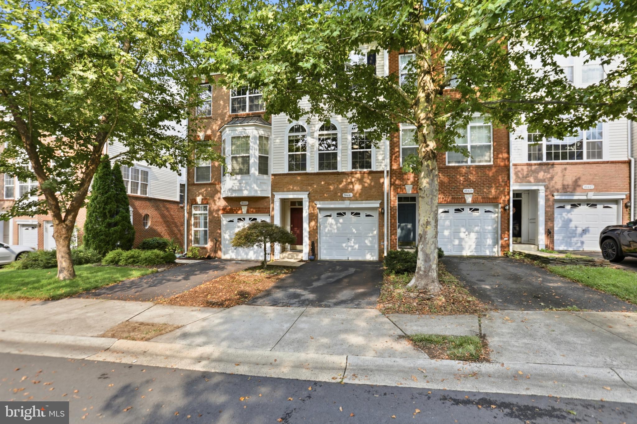 Welcome home to 20441 Scioto Terrace! Located in the highly sought after Belmont Land Bay, positioned within the exclusive Belmont Country Club community. This bright, modern townhouse has 1,718 sqft of finished living  accommodation over 3 levels and has been well maintained throughout. The large front windows allow plenty of natural light to enter the main level of the home, accentuating the spacious and versatile  family and dining room. The home has 3 bedrooms, 2 bathrooms, 1 half bathroom, a spacious kitchen with gleaming granite countertops and plenty of strorage options. This level provides access to a large updated rear deck that benefits from the serenity and privacy of a lush wooded area.  The upper level boasts 2 large bedrooms with vaulted ceilings , both with walk-in closets and a large family bathroom with double sink vanities and linen closet.  The lower level showcases bedroom 3, or a private office if you prefer, a full bathroom, laundry room and access to the gargae. This level also provides access to a private rear yard. The home has been professionally cleaned—making it truly turnkey! Conveniently located just off Claiborne Pkwy with very easy access to route 7, 28, Dulles Greenway,  Ashburn Silver Line Metro Station and Dulles International Airport. The home is positioned just 1.5 miles from Belmont Chase Shopping Mall where you'll find Whole Foods Market, Peets Coffee, Cooper's Hawk Winery and Restaurant, and more dining options. One Loudoun is nearby with its vast array of shops, restaurants, events and other festivities held throughout the year! Enjoy the Belmont HOA's diverse amenities, including the country club, fitness center, pool, walk/jog trails and so much more. Access to the W&OD trail is right around the corner! Oh by the way, Xfinity basic cable and high speed internet service is included in the HOA fee! Enjoy your tour of this lovely home in the well-established Belmont community!