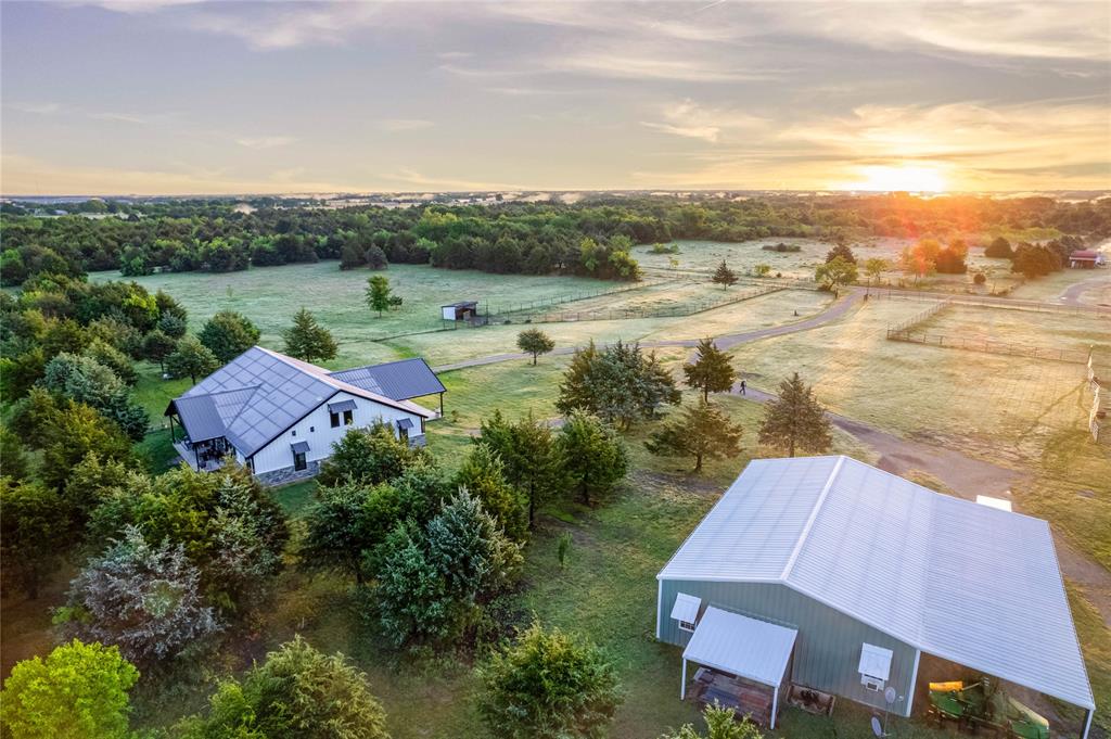 Western Skies Ranch is a premier 171.2-acre recreational and residential ranch located at 3412 Private Road 2173 in Greenville, Texas. Conveniently situated near Greenville, Caddo Mills, and within easy reach of the Dallas-Fort Worth metroplex, this versatile Hunt County property offers a rare combination of privacy, quality improvements, wildlife habitat, equestrian amenities, and outdoor recreation.The ranch features a balanced mix of timber, open pasture, creek frontage, productive bottomland, and level terrain suitable for multiple uses. Improvements include a custom-built approximately 3,396 square foot home with 3 bedrooms, 2 full baths, attached garage, open-concept living area, gas log fireplace, gourmet kitchen with granite countertops, stainless appliances, gas cooktop, breakfast bar, decorative lighting, mudroom with butler pantry, sink, and dog wash. The spacious primary suite includes patio access, soaking tub, and separate shower. Additional features include high ceilings, decorative moldings, French doors, full-size utility space, and metal roof.Additional improvements include an approximately 1,600 square foot shop with an 800 square foot one-bedroom, one-bath apartment ideal for guests, ranch help, or workspace. The property also includes fenced horse pastures, loafing sheds, fenced backyard, bass pond, additional ponds, and creek features.Wildlife includes deer, ducks, and geese, with opportunities for hunting, fishing, horseback riding, ATV riding, hiking, and camping. The property is currently under AG exemption and located within Caddo Mills ISD and an Opportunity Zone through 2026. No known restrictions.Buyer to verify all information including acreage, square footage, schools, taxes, restrictions, floodplain, utilities, and property boundaries.