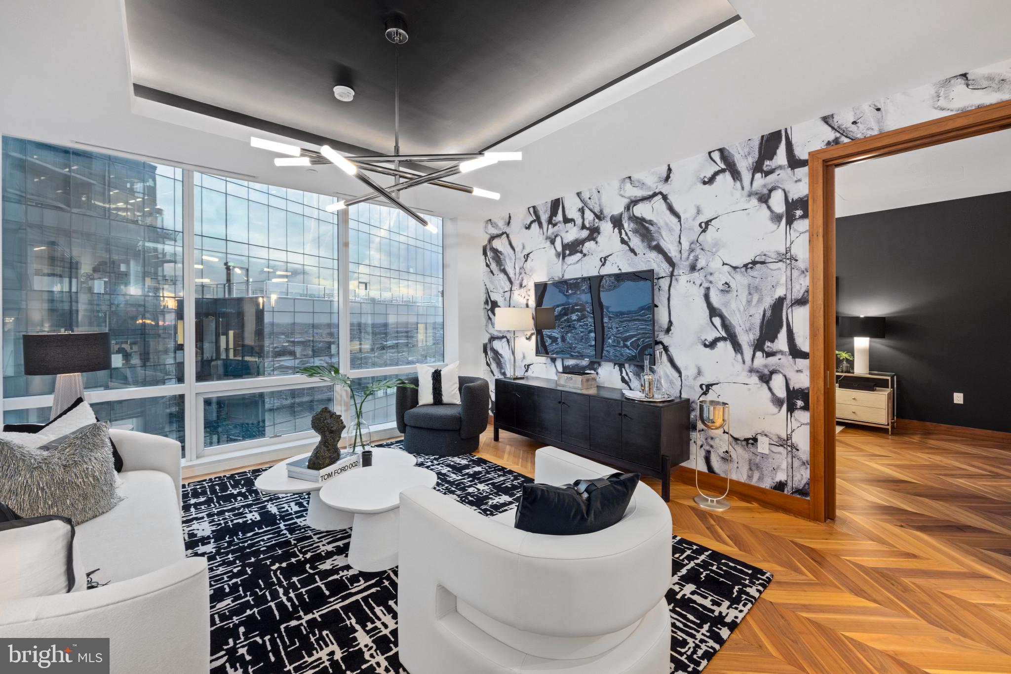 Discover luxury city living in this gorgeous 19th-floor home in the prestigious Four Seasons Private Residences.  Located in Baltimore’s vibrant Harbor East neighborhood, this elegantly designed home features one-bedroom, one-and-a-half-baths, and a den, ideal for an office, work-out space or additional bedroom.  A  spacious open layout seamlessly connects the kitchen, dining, and living areas - perfect for both relaxation and entertaining.  Soaring 10-foot ceilings and floor-to-ceiling windows flood the space with natural light, highlighting beautiful details such as walnut herringbone wood floors, designer lighting, and a chef-caliber gourmet kitchen outfitted with Miele appliances.  The primary suite features a generous walk-in closet and a luxurious marble en suite bath complete with a dual vanity, and soaking tub. Every element is crafted to the highest standard, offering comfort and elegance in equal measure.  Residents enjoy access to the legendary Four Seasons service and amenities, including a private indoor pool and spa, fitness center, restaurants, and meeting rooms,  ensuring a luxury living  experience in one of Baltimore’s most sought-after addresses.  And of course, enjoy the city’s best waterfront dining, boutique shopping, cultural attractions, and recreational activities—right at your doorstep in Harbor East.  *Please note photos are not of this unit, but of a similar unit with the same layout.