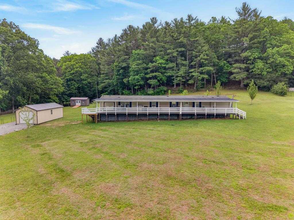 Experience the natural beauty of the Blue Ridge Mountains from this inviting 3 BR 2 BA home set on more than 4 acres of land. This property is perfect as a primary residence, weekend escape, hunting cabin, or recreational retreat. Unwind outdoors on the spacious 800 sq. ft. covered porch, an ideal spot to enjoy the peaceful mountain surroundings. The land features stream frontage, partial fencing, and a wonderful mix of mature hardwoods. A detached one-car garage offers valuable storage and workshop space, while an additional storage building provides plenty of room for tools, equipment, and outdoor gear. Just a short walk to the Jefferson National Forest with direct trail access, you'll enjoy exceptional opportunities for hiking, hunting, wildlife viewing, and year-round outdoor adventure. Don't miss this unique chance to own a beautiful piece of Southwest Virginia.