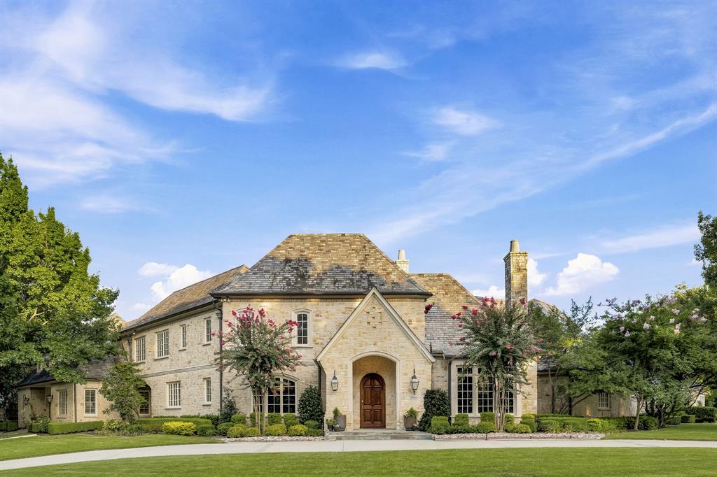 Nestled on a gorgeous half-acre corner lot in prestigious Willow Bend Place near Gleneagles Country Club, this grand stone estate with a slate roof boasts exceptional drive-up appeal that represents the pinnacle of luxury. The home unfolds with dramatic sophistication, highlighted by wood floors that flow throughout the main living areas. The living room commands attention with soaring high ceilings, a massive stone fireplace, and a towering wall of windows. An incredible chandelier casts a warm glow over the dining room. Downstairs, the study features beautifully painted woodwork, a recessed coffered ceiling, a fireplace, and elegant French doors. The gourmet kitchen is anchored by quartzite countertops and an island with a second sink and instant hot water. Perfect for hosting, it features a Sub-Zero fridge, built-in second refrigerator, Dacor six-burner gas range framed by a stone hearth, double ovens, two Dacor dishwashers, large wine refrigerator, and walk-in pantry. This culinary space transitions into a cozy den with a stone fireplace. Upstairs, a spacious media room provides the perfect venue for movies with room to spread out. The primary suite is a true sanctuary, featuring a sitting area, doors to the patio, and a zen-spa-like bath with dual vanities, a freestanding tub, and two walk-in closets. A back staircase leads to the oversized secondary bedrooms, offering extra space and comfort for family or guests. The grand circular drive and gated double porte-cochère lead to a three-car garage, extra parking, and a flat area for basketball. A major highlight of the property, the resort-style backyard features a covered patio with a built-in Twin Eagle gas grill, warming station, and beverage fridge overlooking a sparkling pool, spa, three fire features, and a spacious grassy lawn. Minutes from the community lake, greenbelts, Muehlenbeck Rec Center, premium trails, top public and private schools, and high-end dining, this estate offers an unmatched lifestyle.