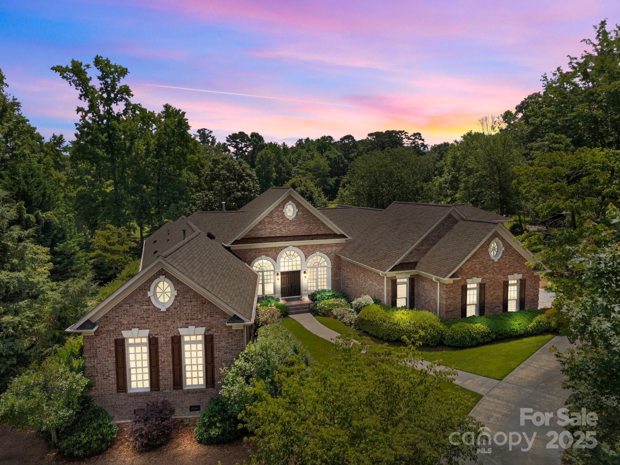 Tucked within a prestigious, gated community with lake access, tennis, and clubhouse amenities, this beautifully appointed residence blends timeless design with effortless everyday living. Sun-filled, open-concept spaces showcase a gourmet kitchen with custom cabinetry, stone countertops, high-end appliances, and an oversized island that anchors the main level for casual meals and lively gatherings. The adjacent great room invites you to unwind by a statement fireplace, while expansive windows frame tranquil views of manicured grounds and mature plantings. A luxurious primary suite creates a private sanctuary with a spa-inspired bath featuring dual vanities, a soaking tub, and a separate shower, plus a generous walk-in closet. Flexible secondary rooms adapt to your life—think office, library, fitness, or media—supported by thoughtful storage and a smart flow for modern living.

Outdoor living is equally compelling. Step out to layered terraces and inviting seating areas that spill onto lush, professionally landscaped grounds perfect for alfresco dining or quiet mornings with coffee. The setting strikes a rare balance of serenity and convenience: peaceful, green, and beautifully maintained, yet close to community amenities that make every day feel like a retreat. Quality millwork, refined lighting, and thoughtful updates run throughout, elevating the home’s warm, sophisticated character. If you’ve been searching for a residence that feels both gracious and livable—with spaces that welcome friends as easily as they embrace solitude—this is the one to experience. Schedule your private tour and feel the lifestyle for yourself.