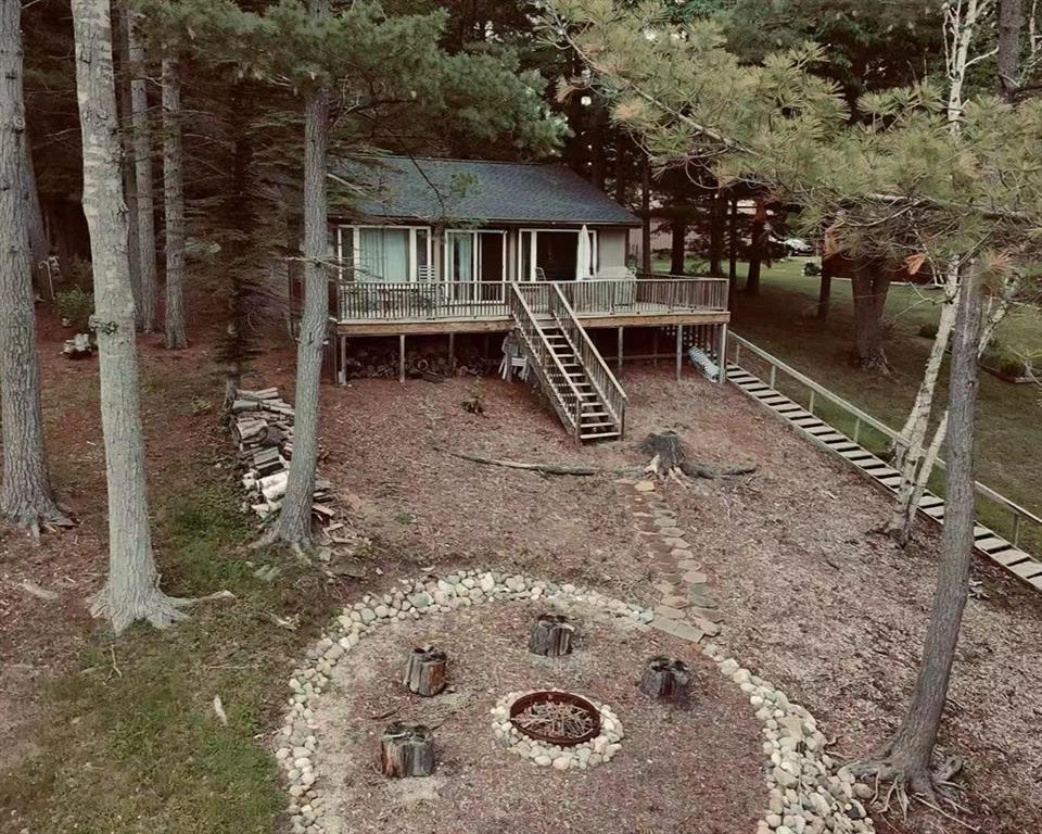 Beautiful 1,100 square foot lake front ranch property with 75 feet of sandy beach waterfront on a more than 325 feet deep lot occupying more than a half acre of private property. Land includes two car garage and shed for additional storage. Easy access to water with extra wide stairs with railing. Outside paint, windows, roof and driveway updated in recent years. Cottage has view of water from open-island kitchen and living room areas. This 3 bedrooms and 1 1/4 baths home is meticulously kept up and move-in ready. New paint, carpet throughout, full kitchen and partial bathroom remodels completed plus installation of cozy gas fireplace. Patio doors allow use of large full-size deck with custom stairs that lead to fire pit area overlooking the water. Lake is all-sports with prime fishing. Water is on schedule to be restored September of 2026. Nearby area is filled with golf, skiing, restaurants/bars and clubs. With under a two and a half hour drive from Metro Detroit this is perfect for a second home or weekend cottagers. The full insulation and forced air heating and cooling allows this to be used all year round.