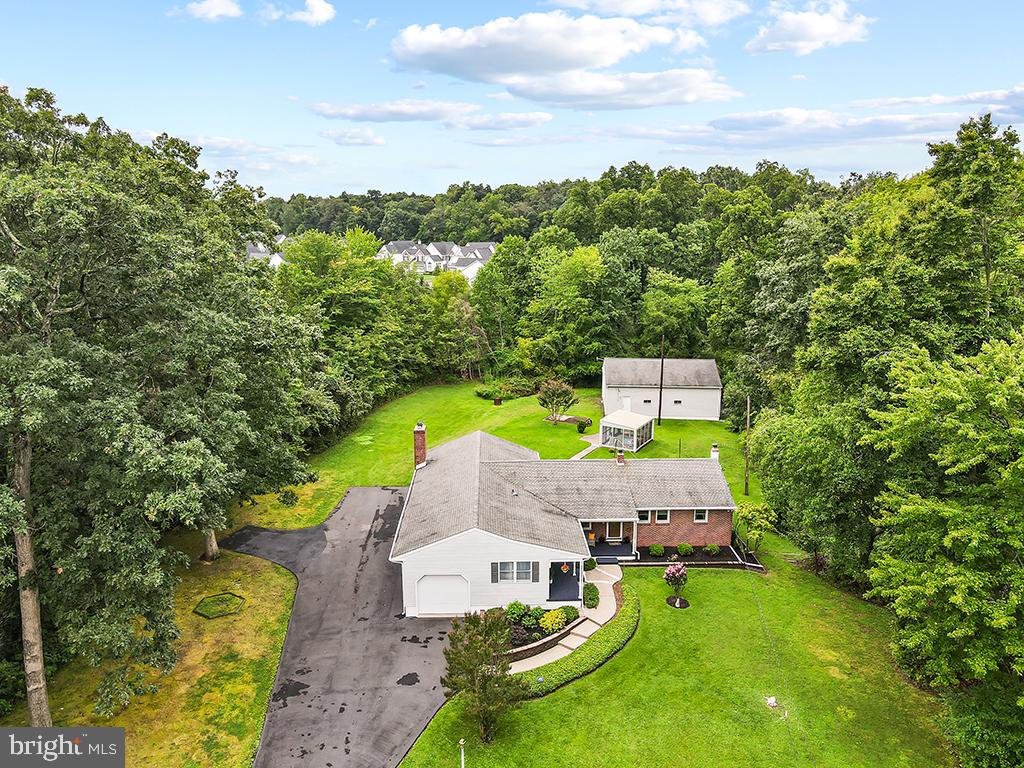 Here's your secluded oasis you've been waiting for!  Don't miss out on this one-of-a-kind ranch home on a private one-acre lot surrounded by the beauty of nature.  This unique property has hardwood floors, new (8/28) carpet installed in 4 rooms.  Large den with views of the open lawn and tree border. Den measures 18.6 x 19 with beamed ceilings. Fireplace currently has insert for propane and can be used as wood burning.  Primary Bedroom suite with full bathroom attached.  Walk-in cedar closet.  Office area.   Kitchen has pantry closet.   Central vacuum. Plenty of storage space and closets.  Generator. Oversized, detached 4-car garage in the back measures 28.8 x 38.7 deep, 11 ft high.   High bay with built in shelving. Air compressor included. (Dayton 350000 BTU heater negotiable.)  Attached one car garage which measures 13.4 x 22.9 with interior access.  Remote control.  Screen house with electric.  10 1/2 x 14 1/2.  Front cover porch. Full basement with workshop and crawl space.  Generator.  Central Air.  2 Sump pumps.  French drain. Bilco doors.   Private septic and well.  2 hot water tanks.  ADT Security System in place which can be transferred.  Property borders community open space - zoned CM, Conservation Management.  Entertaining backyard, perfect for bonfires on chilly nights.   Electrical Boxes:  100 AMP in garage, 200 and 100 AMPS in basement   80 AMP in Bedroom closet.  Plenty of parking!!! Perfect for RV and/or boat.  Fits at least 10 cars.  Award winning Council Rock School District.  Close to airports and train station.  Minutes away from Newtown borough which has many restaurants, shopping and entertainment.  This is a must see!