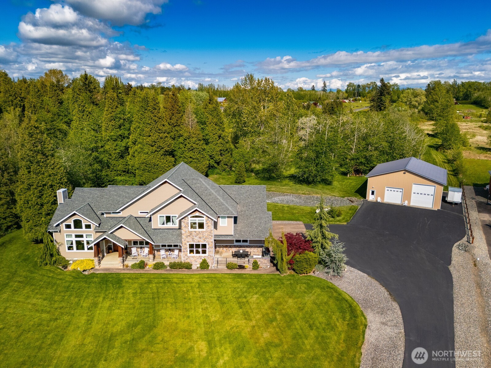 Refined 5-Acre Estate with Luxury Living & Resort-Style Amenities.   This custom-crafted home delivers timeless quality, thoughtful design, and room to breathe. Offering 4 spacious bedrooms, 3.5 baths, and (two primary suites with one on each level, each with heated bathroom floors), this home is built for comfort and flexibility. Ten-and twenty-foot ceilings, wainscotting, crown molding, and vaulted spaces elevate the craftsmanship throughout.   The gourmet kitchen anchors the home with granite countertops, maple cabinetry, Jean-Air appliances, double ovens, gas range, wine and beverage fridges, walk-in pantry, and hardwood floors-ideal for entertaining or everyday living. Gather in the stately dining room or relax in the vaulted living room with floor-to-ceiling stone fireplace, built-ins, and wet bar. Additional features include air conditioning, tankless hot water, whole-house water purification, built-in vacuum, alarm system, generator wiring. The oversized 3-car garage is complemented by a fully insulated 42x48 shop with multiple height tall doors, RV power, welder hookup, wood stove, and new LED lighting-perfect for hobbies & storage. Enjoy outdoor living with covered patio and built-in grill, granite counters, and cedar deck with Bullfrog spa. Located in a gated community with private access to Lake Terrell, this property offers privacy, quality, and lifestyle-inside and out.