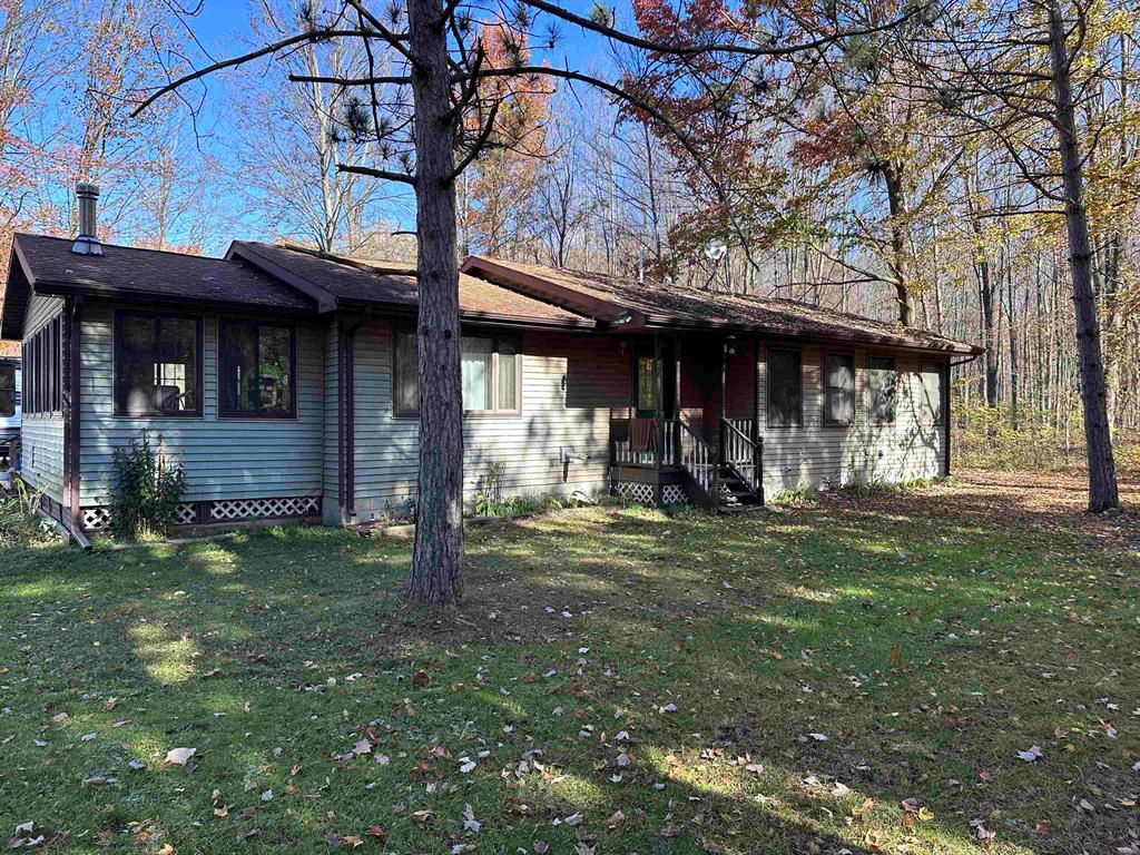 Discover your private wooded haven on 11.02 serene acres! This well maintained home offers the perfect blend of peace, practicality, and modern updates - ideal for hobby farmers, hunters, or anyone seeking a quiet country lifestyle. Surrounded by mature trees and wildlife, the property features a medium-sized pond and multiple outbuildings, providing endless possibilities for storage, workshops, or animals. Youll find a spacious living room that opens to a large three-seasons room, perfect for relaxing and enjoying nature year-round. The updated kitchen and bathrooms blend modern comfort with country charm. A back deck overlooks the peaceful landscape, creating the perfect spot for morning coffee or evening sunsets. Two-car garage includes a workshop space - ideal for projects or hobbies - and there are additional outbuildings for all your tools, toys, or livestock needs. Whether youre looking to start a small homestead, enjoy hunting right out your back door, or simply unwind in a private, wooded setting, this property has it all. Dont miss your chance to own this rare slice of countryside tranquility!