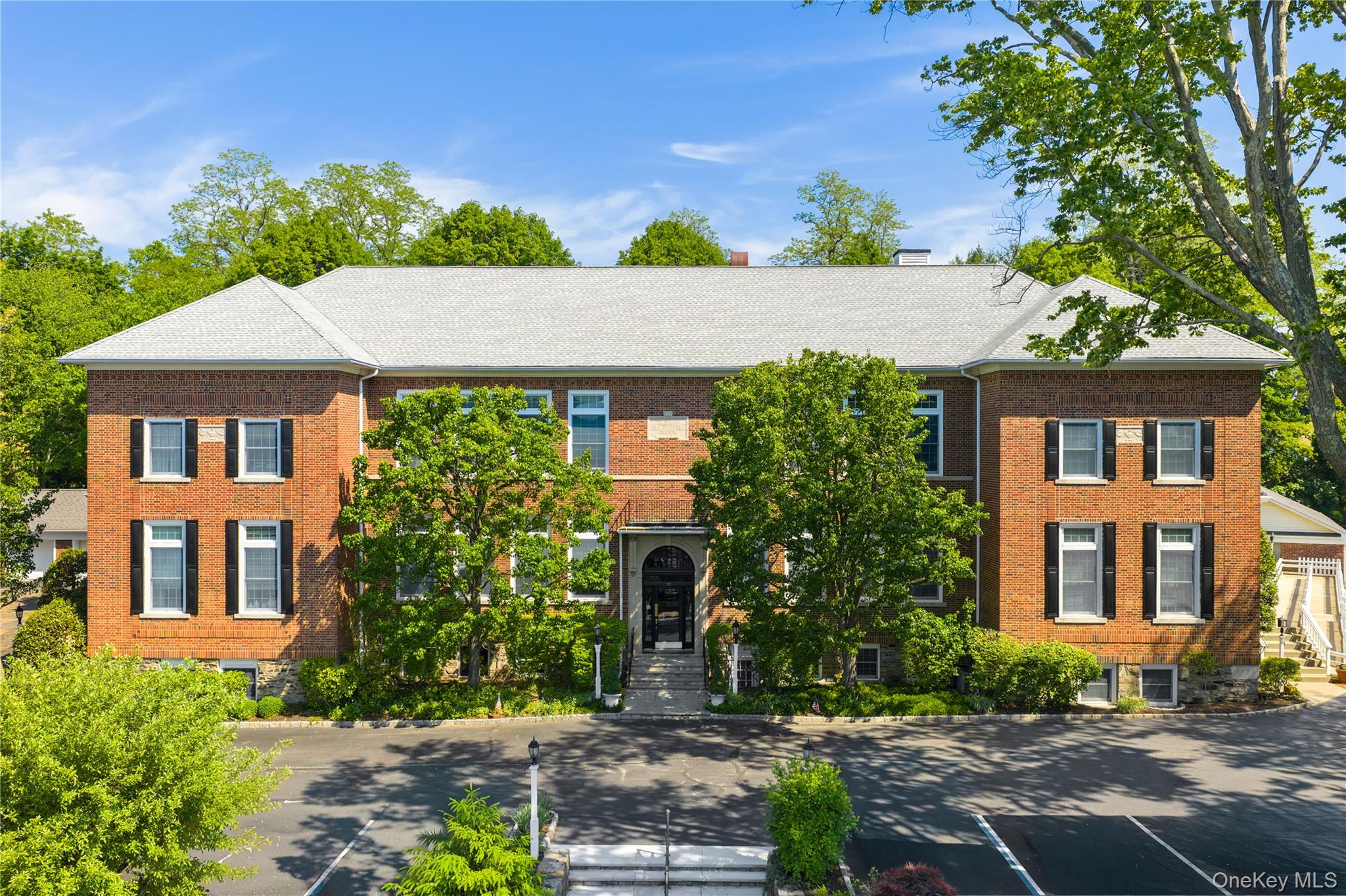 Charming Studio Condo in the Heart of Armonk. History Meets Modern Living.Step into something truly one-of-a-kind. Nestled within a beautifully converted historic brick schoolhouse, this thoughtfully designed studio on the second floor of a secure elevator building offers a lifestyle that is anything but ordinary.Soaring, oversized windows flood the open floor plan with an abundance of natural light, creating an airy, loft-like atmosphere that makes every square foot feel expansive. The custom murphy bed and custom-designed barn doors are architectural statements in their own right, elegantly concealing a smartly organized closet system that maximizes every inch of space. This is not your average studio. The kitchen is fully equipped and efficient, featuring stainless steel appliances, granite countertops, and open shelving. Everything you need, nothing you don't. The open living and dining area flows seamlessly, offering flexibility for how you live and entertain. Set on beautifully landscaped grounds with lush green space, a community barbecue area, and outdoor seating, the property is as welcoming outside as in. The unit includes a private oversized one-car garage plus one additional outdoor parking space, a rare and coveted find. Located steps from all that Armonk village has to offer; dining, shopping, parks, and more. This meticulously maintained building with common laundry on the lower level combines historic character with modern convenience in a truly special package.