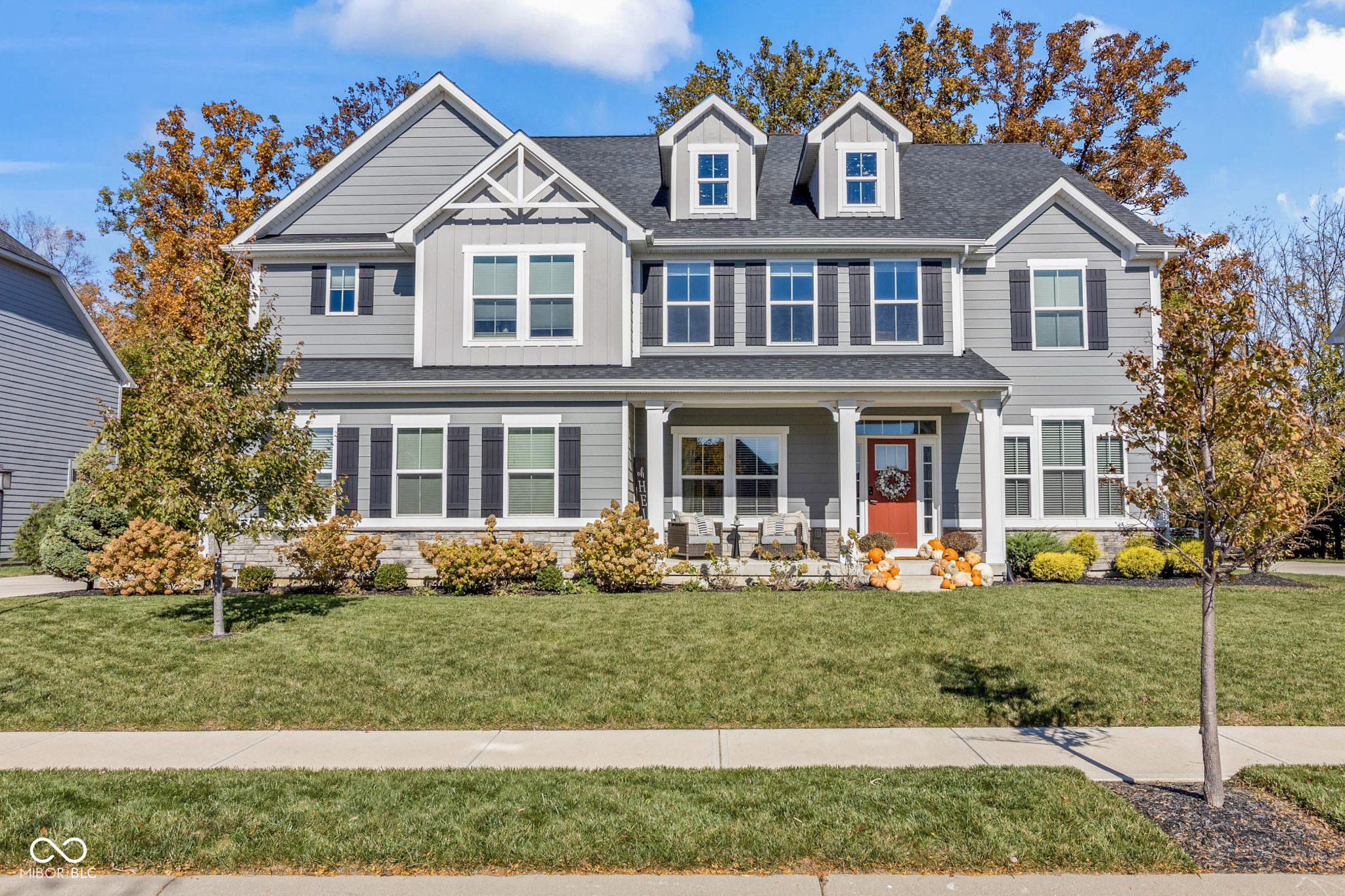 Welcome to this exceptional 6-bedroom, 5-full-bath home in the sought-after Turnberry neighborhood within HSE Schools. Set on a private lot that is both tree-lined and partially wooded, the property features an expansive, partially covered deck-perfect for outdoor dining, entertaining, and unwinding in a peaceful natural setting.    Inside, soaring ceilings and abundant light create a warm, open feel. The two-story great room with a floor-to-ceiling stone fireplace flows seamlessly into the gourmet kitchen, complete with stainless steel appliances, quartz countertops, a large island, double ovens, and a walk-in pantry. A spacious mudroom with a built-in desk and a dedicated main-level office add everyday convenience.    The main level also includes a bedroom with a full bath-ideal for guests or multi-generational living. Upstairs, a large loft provides a versatile second living area perfect for play, movie nights, homework, or a cozy lounge space. You'll also find an upstairs laundry room and generously sized bedrooms.    The finished basement offers a stylish wet bar, electric fireplace, expansive rec space, and an additional bedroom with its own full bath, plus a large unfinished storage room.    A 3-car garage and modern, low-maintenance finishes throughout complete this impressive home. With flexible living spaces, wooded privacy, and a standout deck, this property delivers comfort, function, and elevated living in Fishers.