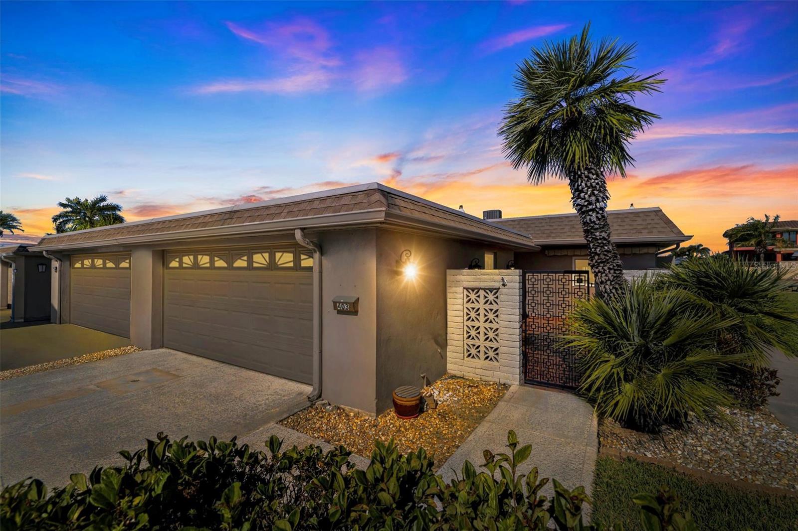 One or more photo(s) has been virtually staged. Welcome to Boca Ciega Point, a gated 55+ WATERFRONT BOATING COMMUNITY in St. Petersburg offering a relaxed coastal lifestyle just minutes from Madeira Beach and direct Gulf access. This MOVE-IN-READY waterfront villa is perfectly positioned on a PROTECTED COVE along a wide canal, tucked into a quieter section of the neighborhood where you can enjoy peaceful water views without the harsh western sun. From your private composite dock and 13,000-pound boat lift, you can be out to the Gulf in just minutes. The dock is equipped with water and electric, a catwalk for easy boat cleaning, accommodates a pontoon lift, and even offers a convenient kayak launch. Evenings here are unforgettable, with breathtaking sunsets reflecting across the water and dolphins and manatees frequently gliding by like familiar neighbors. As an END UNIT with no abutting neighbors on one side, this residence enjoys added privacy and an expansive green space alongside the home making it easier to slip around to load the boat, launch kayak, bring larger things in through French doors, or simply enjoy the extra privacy. The wide grassy common area next to the condo has been perfect for playing with grandchildren and letting the dogs run around. The wider floorplan, enhanced by a RARE 2-CAR GARAGE and double driveway, creates a more spacious feel throughout. An 11 x 23 air-conditioned and heated rear patio with a mini split brings the total living space to just under 2,000 square feet and allows for year-round enjoyment of the water views. The primary bedroom offers tranquil water vistas, while the open front patio welcomes you home with charm and curb appeal. Inside, everything has been thoughtfully updated, restored, and meticulously maintained. The kitchen features upgraded lower drawers for added function, and three solar tubes invite beautiful natural light into the home. The property is fully permitted and up to current code, with electric AFCI ARC breakers, hurricane-rated windows, shutters, and a hurricane-rated garage door protecting every opening. Additional features include a two-year-old A/C system, brand-new water heater, water softener, laundry sink in the garage, insulated patio space, and community fiber-optic readiness. Boca Ciega Point offers 24/7 gated security and an impressive array of amenities, including tennis, pickleball, bocce ball, putting green, swimming pool, sauna, fitness center, billiards room, yoga classes, card games, boating club, social club, extensive library, overflow guest parking, maintenance crew, and more. The comprehensive HOA fee of $1,312 per month includes building insurance, flood insurance, roof coverage, water, sewer, trash, cable, internet, grounds maintenance, and virtually everything except electric, delivering a truly maintenance-free waterfront lifestyle. With John’s Pass, Seminole City Center, numerous restaurants, and world-famous beaches just minutes away, this exceptional villa offers not just a home, but a way of life. Come enjoy a place that will gift you countless hours fishing off the dock or just sitting with friends, a glass of wine in hand, letting the calm wash over you.