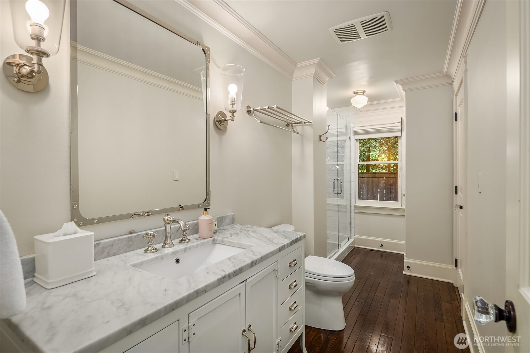 Well-appointed bath features a glass shower and marble vanity