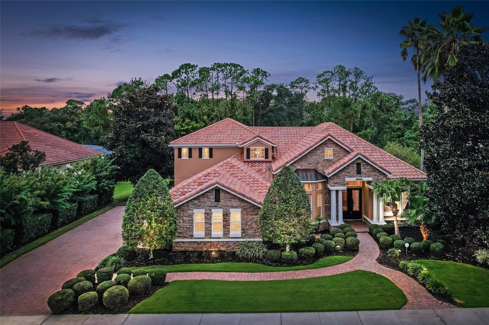 This Parade of Homes Winner at 130 Osprey Hammock Trail is one of the premier residences in the gated Estates at Wekiva Park. Backing to a protected preserve, the home offers exceptional privacy and a natural backdrop where deer and wildlife are frequent visitors, with Wilson’s Landing Park just beyond providing scenic trails, river access, and open space for outdoor enjoyment. Recent improvements include refinished wood floors in 2025, a new HVAC system in 2024, and the exterior of the home professionally repainted in 2025. Inside, the home features engineered wood flooring, tray ceilings, custom lighting, and surround sound throughout, along with a gourmet kitchen equipped with GE Monogram appliances, gas stove, double ovens, warming drawer, dual sinks with disposals, a butcher block island with prep sink, walk-in pantry, and butler’s pantry. The owner’s suite offers custom closets, a Jacuzzi tub, and a walk-in shower with eight shower heads. A key highlight is the large guest suite on the main level, complete with its own dedicated bathroom and direct access to the pool, making it ideal for guests or multi-generational living. Upstairs includes two additional bedrooms, a spacious bonus/game room with a full kitchen, and a theater room. Additional features include a 3-car garage, dual staircases, an office with built-ins, oversized storage closets, a heated pool and spa, summer kitchen with grill and refrigerator, and a barrel tile roof, all with convenient access to SR 429, SR 417, and I-4.