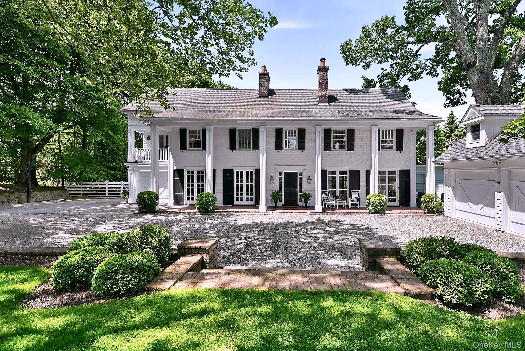 Timeless elegance meets relaxed country chic at this extraordinary Chappaqua retreat. Ideally situated on one of Chappaqua's most coveted streets, this remarkable residence was originally built in 1910 and completely renovated and reimagined in 200l and then again in 2009 for modern living. Privately set amid beautifully landscaped grounds, 40 Algonquin blends classic country manor-style architecture with warm sophistication and resort-inspired outdoor living.A stately columned facade creates a striking first impression, while inside, expansive rooms, oversized windows, and sun-filled spaces create a bright yet inviting atmosphere throughout. Thoughtfully designed living spaces offer effortless flow for both relaxed everyday living and entertaining. This 4-bedroom home lives like a 5-bedroom, offering outstanding flexibility for guests, au pair, home office, or multigenerational living.Light-filled gathering spaces include a gracious den/library anchored by a fireplace, formal living room and an expansive family room with wood plank flooring and its own custom wood framed fireplace thoughtfully designed for comfortable living and effortless entertaining The beautifully updated chef’s kitchen is truly the heart of the home, featuring a redesigned center island, stainless steel appliances, and its own wood burning fireplace. The kitchen flows seamlessly into a stunning sun-filled dining area framed by a dramatic wall of windows overlooking the expansive outdoor terrace — creating the perfect setting for both everyday meals and memorable gatherings.A private main-level guest suite with en-suite bath adds wonderful convenience and flexibility for visitors or extended stays.Upstairs, A generously sized bedroom with en-suite and office/den flex space that lead to the tremendous primary suite retreat, complete with fireplace, dual bathrooms, two oversized walk-in closets, and a separate office or flex space with balcony to have your morning coffee. The third level offers an additional bedroom with loft/gaming area with full bathroom and an additional storage/Flex space.The renovated lower level adds impressive lifestyle space with a private gym, updated full bath, and beautifully finished recreation area ideal for entertaining, play, or relaxation. Walk-out directly to the patio where the pool and hot tub create the ultimate outdoor retreat.The backyard is truly spectacular — a private resort-like oasis featuring a gorgeous gunite pool and spa, sprawling lawns, mature specimen plantings, multiple lounging and dining areas, and incredible privacy. Designed for both entertaining and peaceful retreat, the outdoor spaces deliver the lifestyle today’s luxury buyers are seeking.Ideally located just minutes to town, train, and Chappaqua Central School District award-winning schools, 40 Algonquin offers the rare combination of timeless charm, modern comfort, and elevated estate-style living- all in one of Westchester's most coveted settings.