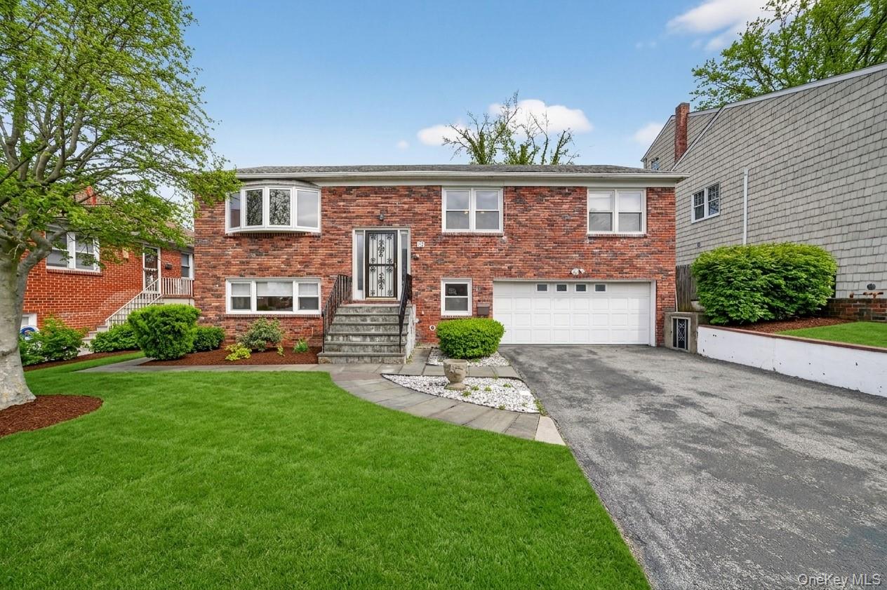 Discover the perfect blend of comfort & convenience in this impeccably maintained Raised Ranch located in one of Yonkers' most peaceful neighborhoods. From the moment you arrive, the newer roof & manicured landscaping signal a home cared for with pride. The interior is flooded with natural light, showcasing an expansive open-concept layout & polished hardwood floors. The main level hosts 3 spacious bedrooms, including a primary suite with its own full bath, while the finished lower level serves as a versatile retreat with a family room, office, & powder room. Outdoor entertaining is a breeze on the private rear deck where you can take in scenic views of the Palisades while overlooking the lush, private backyard. Practicality meets luxury with a 2-car garage & oversized driveway. This home offers a serene lifestyle while remaining just minutes from the Metro-North, major highways, & vibrant local dining. You won't be disappointed!