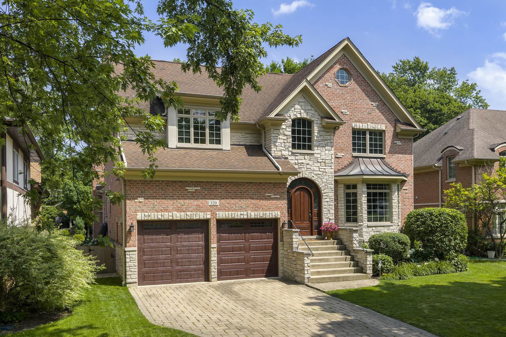 Timeless design, natural light, and incredible space come together at 320 Vista Drive-an exceptional Wilmette home in a truly coveted location. Tucked on a quiet, tree-lined block just minutes from Centennial Park's top-notch swimming, tennis, and ice skating facilities-not to mention award-winning schools-this brick and stone residence offers over 5,000 square feet across four thoughtfully finished levels. With 5 bedrooms, 4.1 baths, and refined architectural detail throughout, this home is move-in ready and built to elevate everyday living.  Constructed in 2006 and maintained in pristine condition, the home welcomes you with soaring ceilings, gleaming hardwood floors, and custom millwork. At its heart is a sunlit family room anchored by a fireplace and framed by oversized windows-flowing seamlessly into the chef's kitchen, breakfast area, and a flower-lined deck perfect for coffee mornings or summer entertaining.  The kitchen is outfitted with premium SubZero, Wolf, and Bosch appliances, expansive countertops, custom cabinetry, and lush backyard views. Formal living and dining rooms offer elegant spaces for hosting, while the generous mudroom and heated 2-car garage (with extra-tall ceilings and built-in storage) keep daily life organized and easy.  Upstairs, the luxurious primary suite features tranquil, tree-filled views, a spa-inspired bath, and a walk-in closet. Three additional oversized bedrooms include a private en suite and a Jack-and-Jill pair, each with large closets. A second-floor laundry room adds day-to-day convenience, and the third floor offers flexible, finished space ideal for a playroom, guest area, creative studio, or teen hangout.  The light-filled garden-level basement is a true extension of the home, with a large rec room, wet bar, full bath, fitness room, and a dedicated office that could serve as a 5th bedroom. There's even a tucked-away space perfect for a wine cellar or Costco closet.  Outside, enjoy a fully fenced backyard with mature landscaping, ultimate privacy, and a spacious deck made for gathering. Located in the award-winning Wilmette/D39 and New Trier school districts, and just a short walk to Westmoreland Country Club, this home checks every box for style, function, and lifestyle.