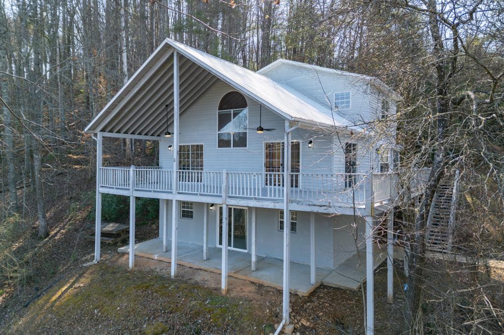 Wake each morning to the sound of the Hiawassee River and end each day with mountain views stretching across the horizon. At 144 River Watch Terrace in the River Ridge community, this riverfront home offers year-round water and mountain views in a setting known for scenic, well-maintained mountain living. Built in 1994 and thoughtfully updated throughout, the home offers nearly 3,000 square feet of inviting space designed to keep nature front and center. Expansive windows draw in natural light and frame the river and mountain backdrop, creating a constant connection to the outdoors. A wrap-around porch and covered front deck provide ideal spaces for morning coffee, quiet afternoons, and evenings spent listening to the water below. The updated kitchen flows comfortably into both breakfast and dining areas, making everyday living and entertaining feel effortless. A wood-burning fireplace anchors the main level, adding warmth and character during cooler mountain seasons. Bedrooms are thoughtfully positioned on each level—including a private owner's suite in the upper loft—offering flexibility and privacy. The finished basement expands the living space with an entertainment area, additional bedroom, and bath, creating an ideal setup for guests or extended stays. River Ridge is often associated with upscale, scenic mountain living, and this location places you just minutes from downtown Murphy, Erlanger Western Carolina Hospital, and the renowned John C. Campbell Folk School. Outdoor recreation is woven into daily life here—whether fishing, kayaking, floating the Hiawassee, or exploring nearby hiking and biking trails. For evenings out, Harrah's Cherokee Valley River Casino is just a short drive away. Properties that offer year-round mountain and river views, updated interiors, and a location this convenient to town are increasingly hard to find. Here, the setting does more than surround you—it defines the way you live.