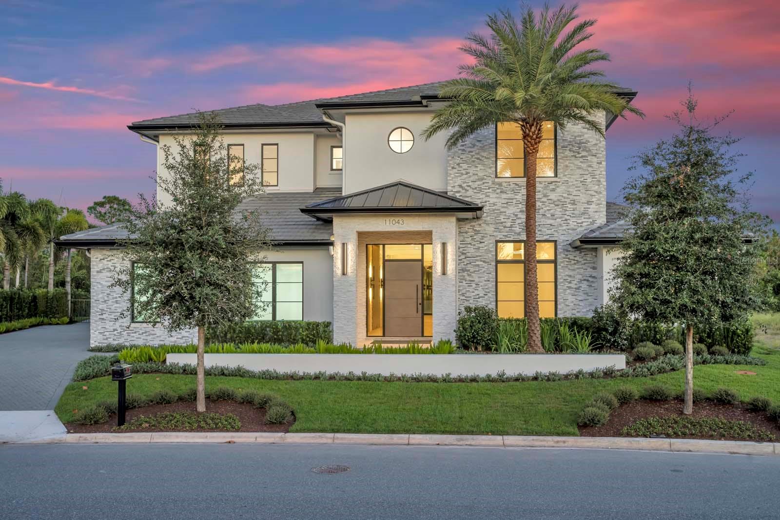 One or more photo(s) has been virtually staged. Expertly built by Maroon Fine Homes, and located in the new Cromwell expansion at Lake Nona Golf & Country Club, this luxurious custom home is perfectly situated with direct access to the Club’s amenity base, The United States Tennis Association’s National Campus, and Lake Nona’s Town Center.The warm, contemporary residence boasts five bedrooms, five full and two half baths, ranging over an impressive 6,000 sq. ft. floor plan. Custom floor to ceiling millwork, with integrated lighting, and a floating stair case create a stunning entry into the home’s open floor plan. A private, glass enclosed study precedes the large great room, which is set against the serene conservation views, and is anchored by the gorgeous gourmet kitchen and stunning fire place. In addition to the first-floor guest suite and sitting room, the main level features the expansive owner’s suite complete with a spa-like primary bath and a 13’ by 26’ custom walk-in closet inspired by a luxury merchandise experience and offering a private vanity.  The beautiful landscaping highlights all this home has to offer and is the perfect backdrop to the spectacular outdoor oasis complete with multiple covered lanais, a resort-style plunge and lap pool, spa and summer kitchen.  Additional features include a Scullery Kitchen, Second Floor Loft, a Three-Car Garage.