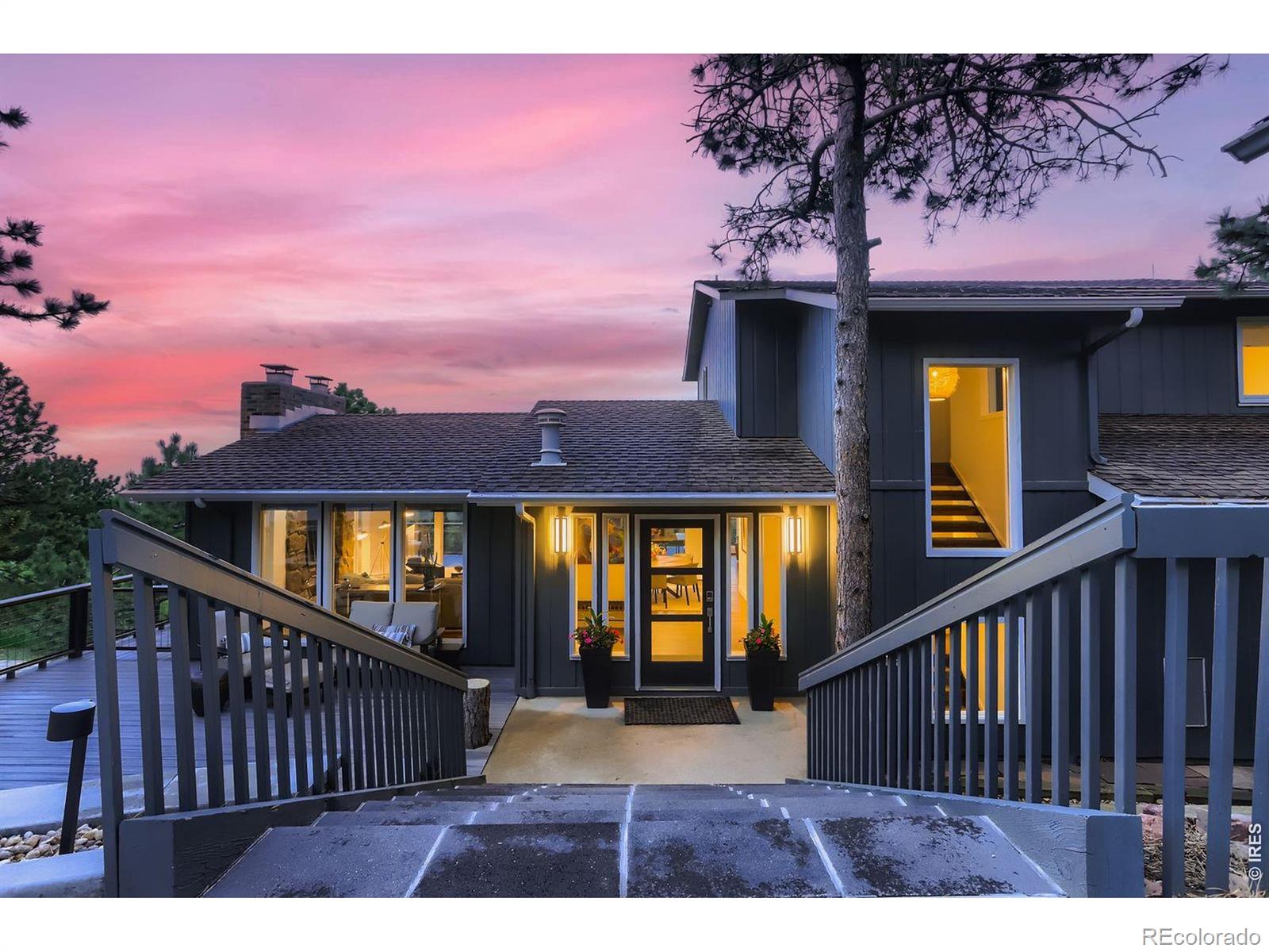Located just minutes from downtown Boulder, this stunning home delivers the rare combination of close-in convenience and serene foothills living. Sweeping mountain views, twinkling city lights, and Boulder's famous pink-sky sunrises and sunsets are your everyday backdrop, with floor-to-ceiling windows on all three levels bringing the scenery inside. Step out your door and onto the Lion's Lair trail up Mount Sanitas - or hop in the car and reach Ideal Market in about 12 minutes and Pearl Street in 15. New white oak flooring anchors the light-filled main level, where a wall of windows frames the panorama across an open flow of living room with fireplace, sitting area, dining space, and kitchen. The remodeled kitchen centers on a dramatic quartzite waterfall island and stainless steel appliances - a true gathering point for cooks and guests alike. A main-level bedroom and full bath add flexibility, while the office is tucked behind a maple barn door handcrafted by a local artisan. Outside, a brand-new wrap-around Trex deck extends the living space into an entertainer's dream: gas line, gas fire pit, gas grill, saltwater hot tub, and a fully fenced yard ready for everything from quiet evenings to lively get-togethers. Upstairs, the primary suite is a true retreat ... wake up to the views, then warm your feet on the heated floors of the beautifully updated bath. The walk-out lower level is built for fun: a spacious rec room with an entertainment center and full bar, additional bedrooms and a bath, and new luxury vinyl tile throughout. Behind the scenes, this home is dialed in: Mitsubishi A/C, Nest smart-home integration, Xfinity security, timed driveway lighting, an irrigation system, and a Flo by Moen water-monitoring system for added peace of mind. Recent upgrades include a new furnace, hot water heater, water softener, reverse osmosis filtration, fresh main-level insulation, and new electric sunshade blinds.