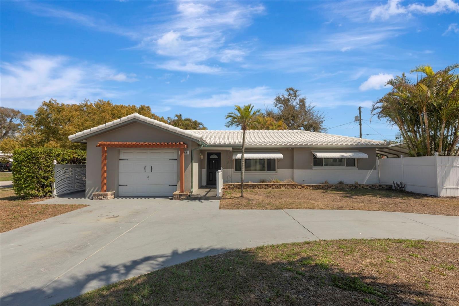 Attractive 2-bedroom, 2-bath pool home on an extra-large corner lot offering comfort, style, and exceptional outdoor living.The home has been thoughtfully updated with granite countertops, new appliances, a brand-new washer and dryer, luxury vinyl plank flooring, an updated electrical system, a new hot water heater, and a brand-new electric garage door opener. The 2019 tile roof is designed for long-term durability and secured with hurricane straps and clips rated for winds exceeding 150 mph. A wind mitigation inspection completed last year significantly reduced the owner’s insurance costs. A high-quality Goodman AC system installed in 2016 and newer double-pane windows help keep the home comfortable and energy efficient.Step outside to enjoy a private backyard retreat featuring a low-maintenance 15x8 in-ground pool surrounded by Spanish tile and a stylish fire pit perfect for relaxing or entertaining. A recently installed brand-new commercial-grade pool pump helps keep the pool running efficiently. The backyard also features a covered cabana-style grilling area along with tropical landscaping that provides excellent privacy.Additional features include copper-coated lifetime gutters, a sprinkler system supplied by a well that also services the pool, and a finished garage with drywall and a specialty-coated floor. A large shed with electricity and a workbench offers excellent storage or workspace.Along the side of the home is a spacious paved and covered area ideal for an RV, boat, or additional vehicles, protected by an adjustable-height metal roof structure. White vinyl fencing surrounds the property for added privacy.Move-in ready and easy to show. Schedule your private tour today.