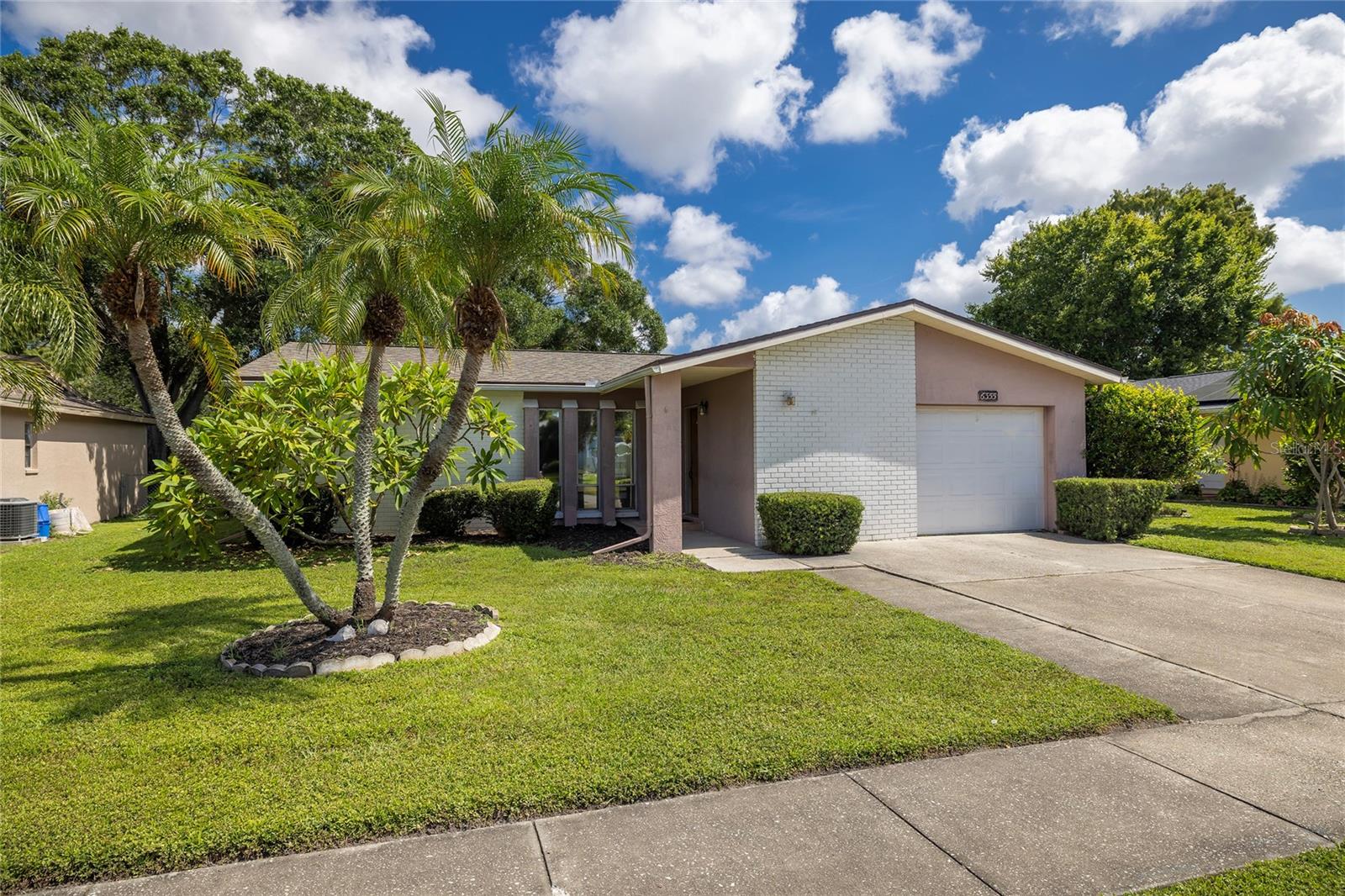 Amazing layout, charming water views and X FLOOD ZONE!! This 3 Bedroom, 2 Bathroom home has a SPLIT plan and SO many amazing features to offer! The roof was replaced in May 2026, the Water Heater was replaced at the end of 2025, and the A/C is 2017. A brand-new slider is on its way, and the back bedroom also has a new window! The living area is HUGE -- great for family gatherings!! Hang your holiday stockings along the wood-burning fireplace! The Dining Space is right off of the adorably updated Kitchen, and the beautiful water views pour in from the large back slider that is being replaced (and permitted). All bedrooms are ample in size, and the Master Bedroom offers a generous walk-in closet and spacious en-suite bathroom. The guest bathroom is gently used and VERY clean! The Laundry Room is located INSIDE, not in the garage. With some fresh paint colors of your choice and your style of new flooring, this home can be transformed into your own personal sanctuary! The rear deck is an amazing and serene place to sit and enjoy your morning coffee, or to finish-off the day with a good book. The street is a peaceful one, not ideal as a cut-through street, so traffic is slim to none! Only a 1-minute drive to grocery shopping and restaurants, a 25-minute drive to beautiful Florida beaches, a 25-minute drive to Tampa Int'l Airport, under 10 minutes to the nearest emergency hospital -- so close to everything you need and near everything that makes Florida-Living the finest!!