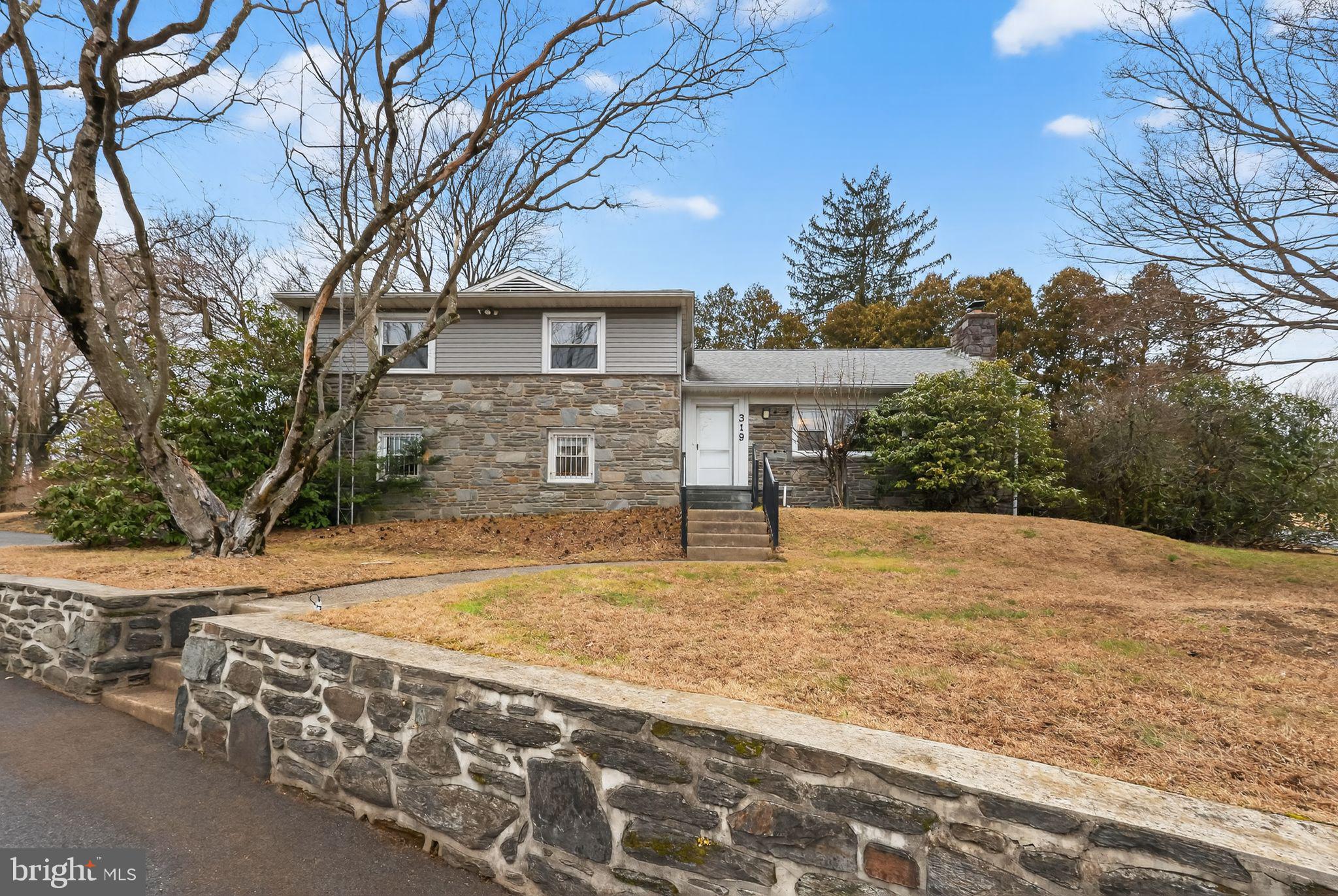 Welcome to 319 Crestview Circle, a well-built,  stone split-level home offering 3 bedrooms, 2.5 baths, and over 2,100 square feet of living space. Situated on more than half an acre, this home is tucked away on a private circle while remaining conveniently close to major highways, just 15 minutes from Philadelphia International Airport, and located within the award-winning Wallingford-Swarthmore School District. Homes in this highly sought-after neighborhood are rarely available, making this a unique opportunity.Although the home is wonderfully retro and carpeted, beautiful hardwood floors run throughout the home, offering an excellent opportunity to restore and showcase their natural charm while adding immediate value. Enter the front door to find a spacious living room featuring a fireplace and a large picture window that fills the space with natural light. The living room flows seamlessly into the formal dining room and adjoining eat-in-kitchen, which offers abundant cabinet and storage space. Just off the kitchen is a generous sunroom with sliding doors that open to a beautiful, secluded patio, perfect for relaxing or entertaining. A short stair leads up to the bedroom level, where you’ll find a large primary suite with two closets, an ensuite bath, and custom built-ins for additional storage. Two additional well-sized bedrooms and a full hallway bath complete this level. This floor also features two separate access points to attic spaces, providing exceptional storage options. Back on the main level, another short set of stairs leads to a powder room and family room, an ideal space for a home office, playroom, or cozy retreat. This level also provides direct access to the attached two car garage. From here, continue down to the finished basement,  a wonderful bonus space for a work out or craft room.  Additional basement area includes the laundry, utilities and additional storage.The expansive back and side yards of this half acre property features two storage sheds and offers plenty of room for gardening, outdoor activities, and entertaining. Residents of the neighborhood enjoy convenient access to the scenic Pendle Hill Trail, which connects to the Leiper Smedley Trail, perfect for walking, running, and enjoying the outdoors. While the home reflects its original vintage character, it offers excellent bones, location, layout, and timeless features, making it the perfect canvas for a buyer to add their own personal touches. Opportunities like this—in a neighborhood buyers covet —don’t come along often. Don’t miss your chance to make this home your own.