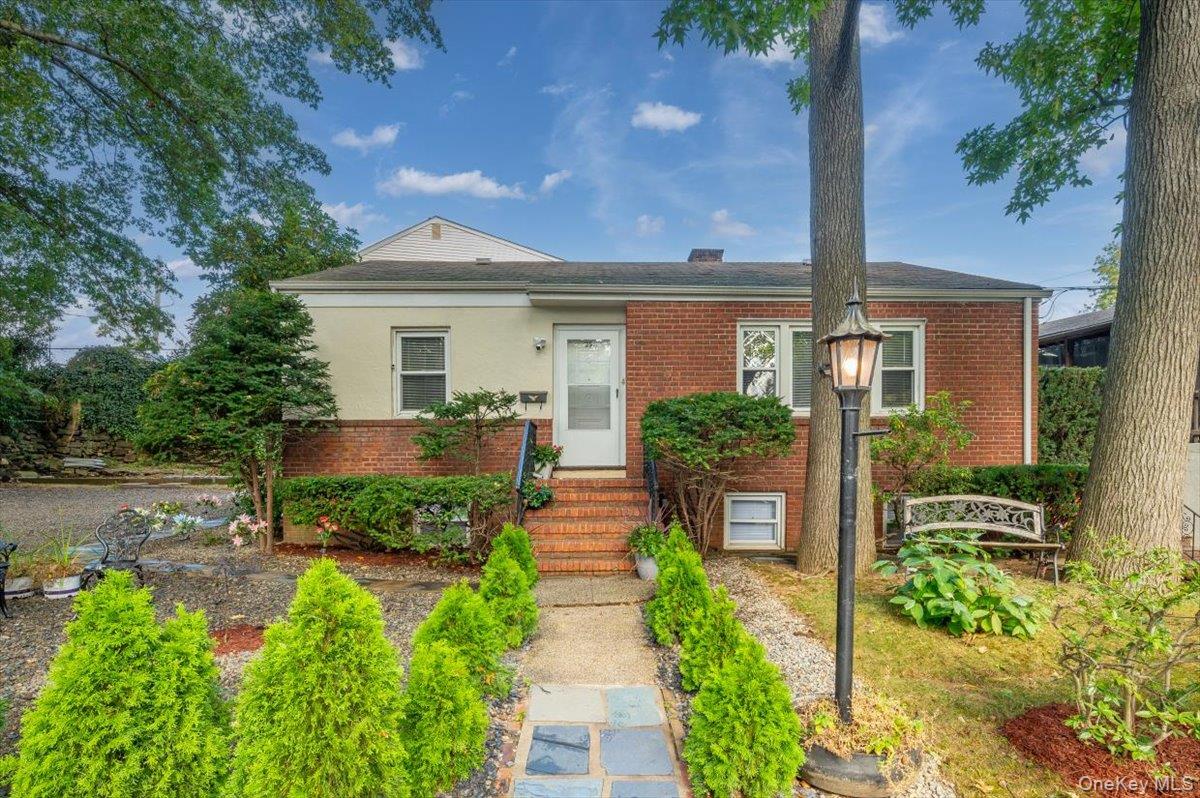 Nestled on a beautifully landscaped corner property in a quiet, tree-lined neighborhood, this impeccably maintained brick  residence offers timeless appeal, modern comforts, and exceptional convenience—all just 25 minutes north of Manhattan. This sun-drenched home features a thoughtfully designed floor plan highlighted by a gourmet eat-in chef’s kitchen, ideal for culinary enthusiasts and perfect for hosting. The spacious living room provides a warm and inviting space to relax or entertain, while the generously sized primary bedroom offers excellent closet space and comfort. Two additional bedrooms provide flexibility for family, guests, or a home office. Immaculate throughout, the home showcases custom crown moldings, designer trims, new flooring, and quality finishes that speak to meticulous care and attention to detail.
The fully finished lower level offers versatile living space, perfect for extended family or guests, and can serve as a large family room, recreation room, or a potential fourth bedroom. A beautifully appointed full bath completes this level, adding to its functionality and charm.
Outside, enjoy a meticulously maintained exterior, featuring an oversized driveway, a detached garage, a private patio ideal for entertaining, and a unique rooftop terrace above the garage—a perfect spot to relax and unwind under the open sky.
Ideally located close to major highways, public transportation, parks, and the Cross County Shopping Center, this home is a commuter’s dream, offering a seamless blend of suburban tranquility and city accessibility. This is a rare opportunity to own a turnkey home that combines luxury, comfort, and convenience in one of Westchester’s most sought-after communities.