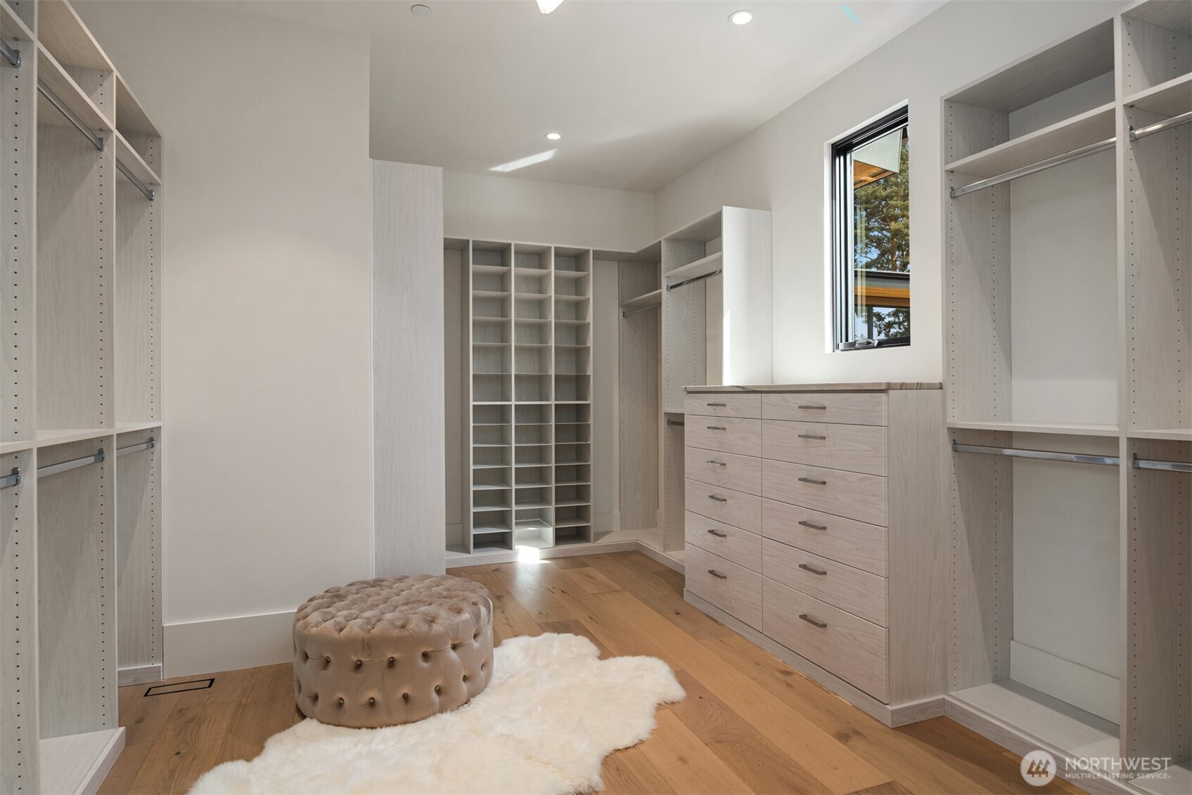 Elegant walk-in closet with custom cabinetry and abundant space for wardrobe and accessories.