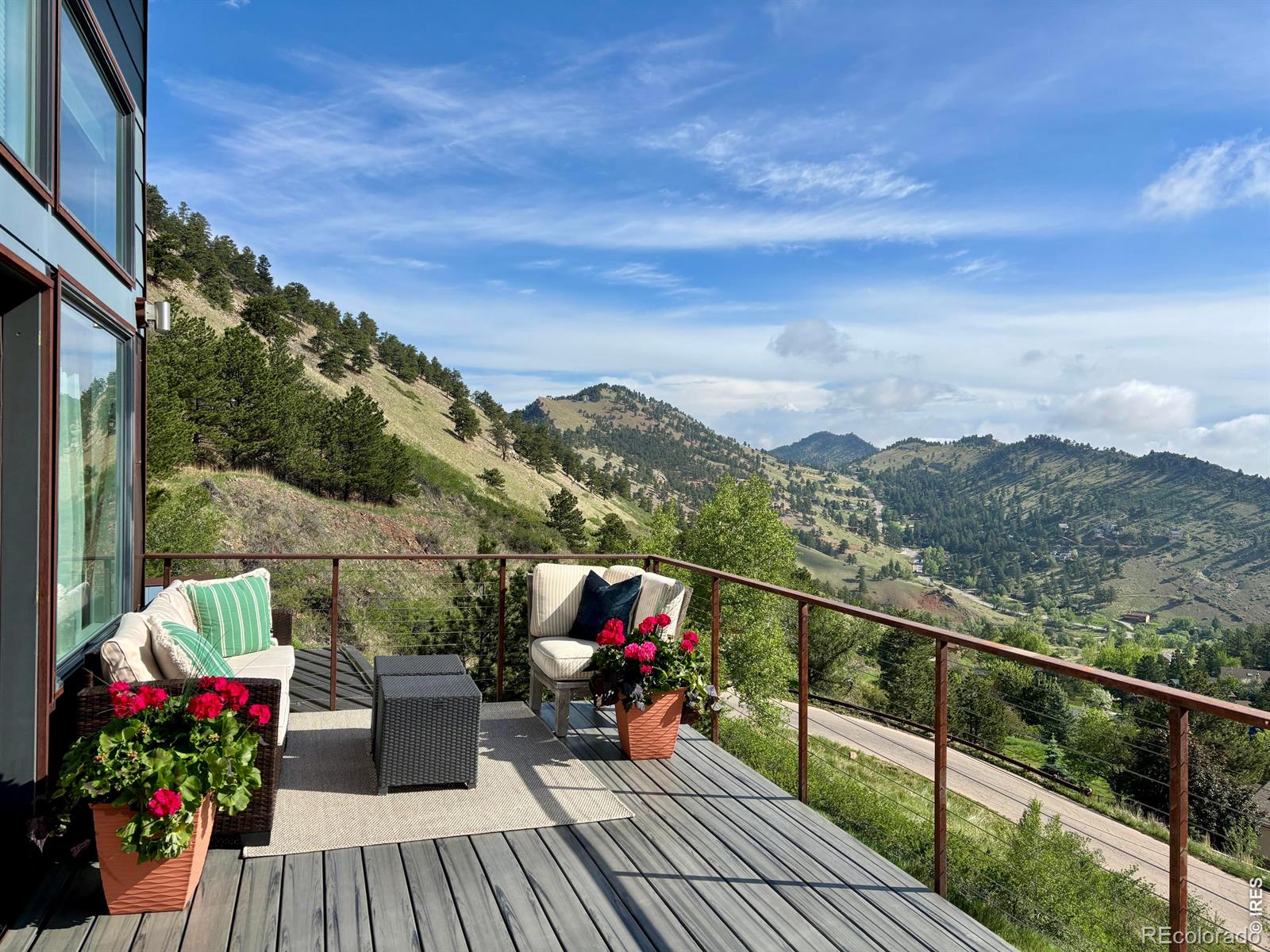 Four bedrooms (two conforming, two non-conforming) and three baths tucked into beloved Pine Brook Hills, just behind scenic Wonderland Lake, five minutes from Broadway and ten minutes from Pearl Street. This modern chalet delivers what Boulder buyers rarely find: genuine privacy, sweeping mountain views, and effortless access to everything the city offers. Locals call the neighborhood "Little Switzerland," and once you're here, you'll understand why. The main floor is designed for living. A generous great room, open living and dining areas, opens to the main deck with sweeping mountain views. The primary suite offers a walk-in closet, its own private deck, a double-shower en-suite, and its own private deck with a chlorine-free hot tub for evenings under the stars. A second conforming bedroom with walk-in closet, a full kitchen, and two full bathrooms round out the main level. Upstairs, a non-conforming studio accessed via its own staircase and sliding barn door floods with natural light and delivers 360-degree panoramic views. Fully flexible, it functions beautifully as a guest retreat, creative studio, or quiet home office. The permitted art studio sits apart from the main house with its own entrance and currently rents for $1,850/month - a 5.09% cap rate representing approximately 21% of property value. It features a sleeping nook, electric fireplace with travertine tile, an overhead fan, and a mini-split for year-round comfort. A separate gear shed adjacent to the art studio handles everything an active Boulder lifestyle demands. Main living areas flow naturally to a generous deck that extends your life into the mountain views - the kind of outdoor space you'll enjoy often. The home also includes central heating and A/C, in-unit washer/dryer, a modern kitchen, updated bathrooms, and a terraced garden with amended soil ready for planting. Hiking trails begin at your door. Barely in the mountains. Steps from everything.