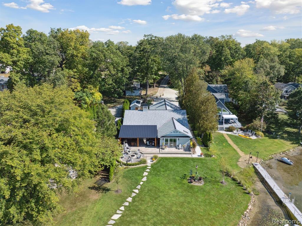 Picturesque waterfront ranch on Lake Chemung in Howell, offering nearly 2400 sq.ft. of beautiful living space! Enjoy lake living year-round with this charming home. Gorgeous open layout with vaulted ceiling and decorative beam, adding character and openness to the space. Fireplace in the living room with partial stone mantel. Living room features wall-to-wall floor-to-ceiling windows and sliding glass doors, welcoming a view of the lake and illuminating the entire space with natural light. Cozy dining space, perfect for enjoying meals or a make-shift work space. Kitchen gives a modern feel with white cabinetry and countertops, plus stainless steel appliances. Large island offers additional countertop space and bar seating, great when entertaining guests. Full bath with shower-tub combo located just off the kitchen area, plus a half-bath for additional convenience. Separate laundry room with utility sink and extra storage is located just off the kitchen. The primary bedroom is spacious with it's own sizeable walk-in closet, full bath with double vanity and glass stand-up shower, and sliding glass doors with direct access to a personal patio with a lakefront view. Attached 3 car garage with half-bath and mini split with heat and AC! Remodeled with wall-to-wall storage cabinets and a wet bar area. Out back, a cozy covered patio area, plus uncovered patio space with fire pit. The primary bedroom has it's own personal patio. Large yard overlooks Lake Chemung, a stone path leading you to the dock. Shed provides storage for outdoor items. Home comes with whole house generator, constant pressure well system, two RO systems (kitchen sink and to refrigerator), dual softener and iron filter, irrigation system fed from lake - pump is included, and water heater on demand tankless. Located five miles from Downtown Howell, local entertainment and restaurants, and easy access to expressways. Make lake living your every day with this gorgeous ranch. Schedule your private tour today!