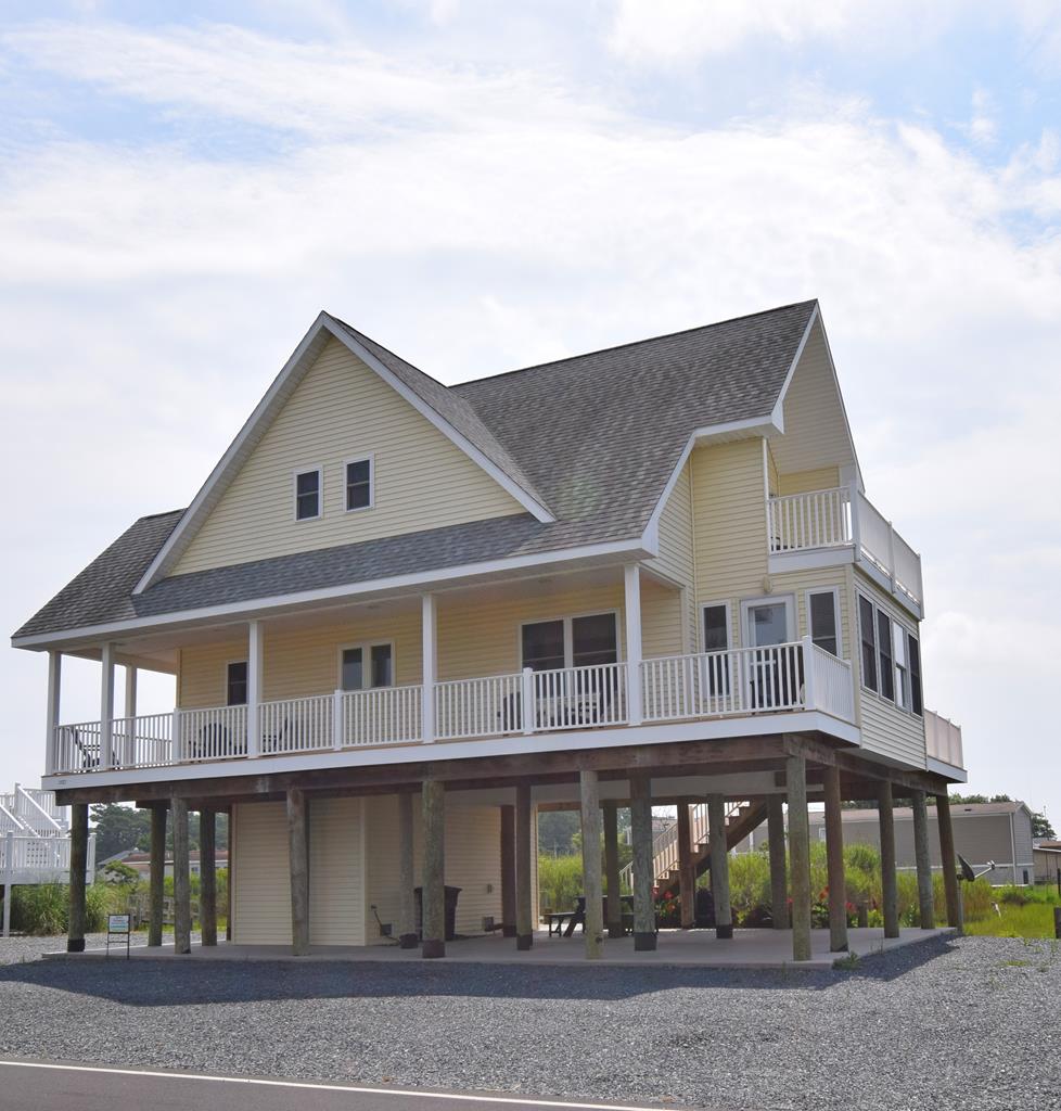 Waterfront Home with two piers! An 80-foot pier with a floating dock on Fowling Creek behind the home. A new 400-foot pier across the street on Chincoteague Channel with a water depth of approximately 4 feet at low tide. Direct views of Wallops Island rocket launches. The house has a total of 638 square feet of decks. The first-floor front covered porch equals 338 square feet. The first-floor rear open deck equals 155 square feet. The private open deck off the 2nd-floor primary suite equals 145 square feet. Both 2nd-floor suites have private full baths. Other Room 1 is the first-floor den/sleeping area, Other Room 2 is the first-floor sunroom. 10' x 22' ground floor storage room. Two-zone HVAC. “Sunset View” is a vacation rental managed by Island Getaways.