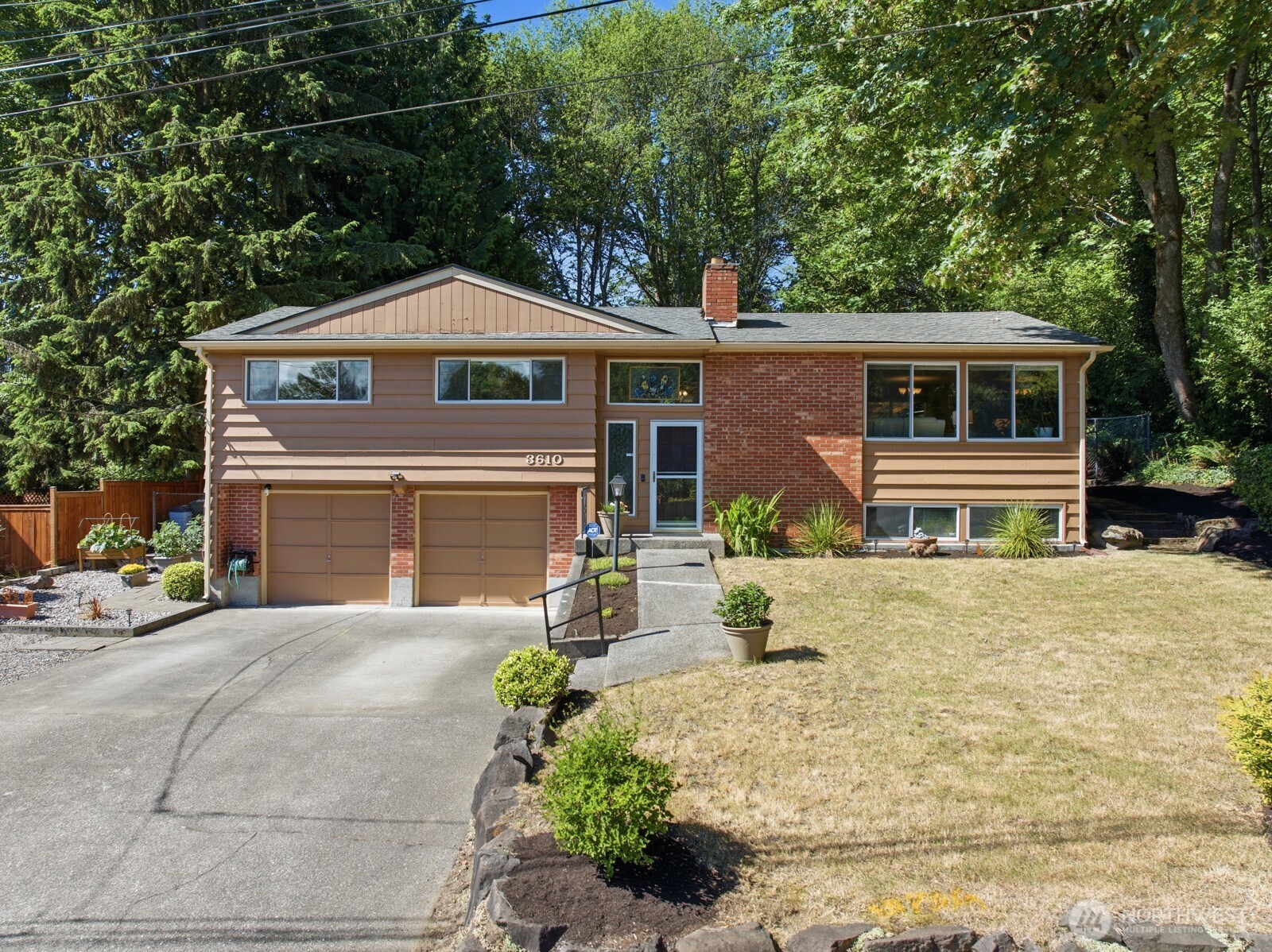 Privacy & a park-like setting surround this quality-built mid-century modern split-level home in coveted Lake Forest Park, tucked away on quiet cul-de-sac. Situated on a buildable shy half-acre lot, this 4-bed/2.75-bath home offers 1,990 sq ft of living space w/potential for multi-generational living & room for future DADU opportunities. Beautiful oak hardwood floors span main level. Spacious formal LR features stunning floor-to-ceiling brick fpl w/raised hearth & lrg 3-pane view windows. Kitchen includes SS appliances, pantry, garden window, warming lights w/hood & racks above stove & casual eating area w/access to expansive covered patio. Formal dining room also opens to expansive patio & backyard - perfect for indoor/outdoor entertaining. Primary suite features ensuite bath w/lrg walk-in shower. Two additional bedrooms & full guest bath complete this level. Lower level offers spacious family room w/dining area & second floor-to-ceiling brick fpl, office, spacious bedroom & generous full bath w/laundry area. Ideal MIL potential. Beautifully landscaped backyard includes 2 outbuildings, entertaining spaces & wired for hot tub. The fenced land beyond yard's back gate is also part of the 18,540sf lot-so many possibilities! Ample parking & RV/boat parking. No HOA. Deeded membership to Lake Forest Park Civic Club including beach & boat access. Conveniently located near schools, shopping, dining & freeway access. Updates in 2021 include exterior paint, kitchen appliances & gutters