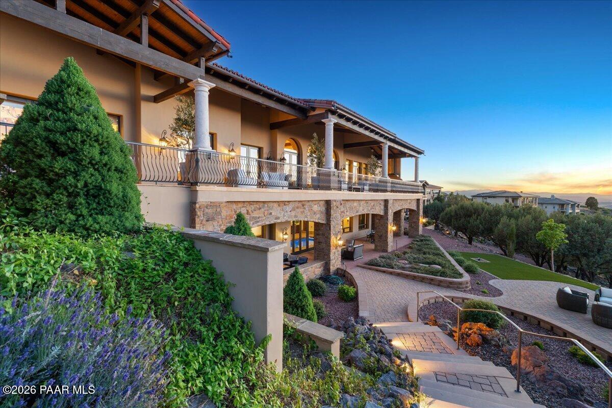 Welcome to ''Casa Di Buona Fortuna'' Architecturally Refined Mediterranean Estate blends timeless elegance with modern luxury while showcasing breathtaking views of the Granite Dells, Watson Lake, and Granite Mountain. A dramatic foyer creates an unforgettable sense of arrival with soaring barrel ceilings, handcrafted radial wood beam detailing, artisan iron chandeliers, rich hardwood flooring, Cantera stone accents, and layered arched openings that establish the home's ''Old World'' sophistication and architectural grandeur. Throughout the residence, custom iron doors, exposed wood beams, artisan stonework, designer finishes and three stunning fireplaces create a warm European-inspired ambiance. The gourmet kitchen features exquisite ''New'' Pegasus Marble countertops, custom cabinetry, premium Miele appliances, a butler's pantry, walk-in pantry with coffee bar, and expansive view windows, while grand living spaces offer soaring ceilings, refined lighting, and seamless indoor/outdoor flow. Spacious bedroom suites offer private en suites, while the luxurious primary retreat features a sitting area with bar, steam shower, and separate his-and-her closets. The courtyard is a stunning expression of modern Mediterranean resort design where timeless European architecture meets relaxed luxury living, creating an atmosphere that feels intimate, sophisticated, and effortlessly elegant. Resort-style courtyards, expansive patios, and a built-in BBQ area create the ultimate entertaining experience, complemented by a gated driveway for privacy and security. Exceptional amenities include a saltwater indoor lap pool, spa, sauna, private his-and-her studies, 300 bottle temperature-controlled wine cellar, workout room, and a spectacular movie theatre featuring step lighting and a fiber optic ceiling. Additional highlights include two elevators, centralized lighting, solar, geothermal efficiency, a safe room, and an expansive 6 plus-car garage designed for luxury collections and convenience. This rare LEED-certified estate masterfully combines craftsmanship, architectural integrity, efficiency, and timeless luxury in one extraordinary offering.