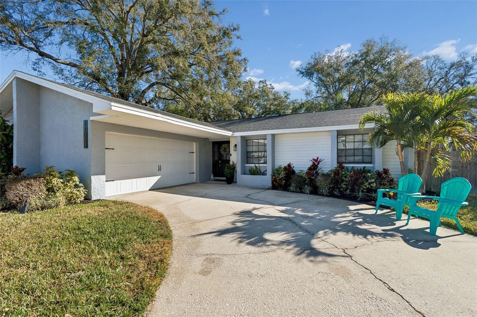 Welcome to this beautiful all-block construction home that has been thoughtfully updated throughout the past five years, making it truly move-in ready. Set back on an spacious 8,500-sq ft lot in the desirable Carrollwood Estates located in flood zone X (no flood insurance required!) this home features 3 bedrooms, 2 bathrooms, a 2-car garage, and an open floor plan drenched in natural light. Enter through the brand new fiberglass front door to the entryway area and spacious living room. The kitchen is the heart of the home where you will want to gather whether it’s for everyday connections or entertaining guests. It features a large island with seating, granite countertops, Shaker-style cabinetry, and stainless steel appliances. A dry bar area with a beverage fridge and built-in pantry provides additional storage and counter space. The window over the sink, dressed with a Roman shade, overlooks the gorgeous backyard, bringing the outdoors in. Adjacent to the kitchen is a separate dining area for more formal occasions. The primary suite offers a private retreat, complete with barn doors leading to a beautifully appointed bathroom with a separate vanity area, a walk-in shower wrapped in Carrara-style tile for a luxe feel, and a walk-in closet. The second bedroom (currently used as a nursery) has recently-installed picture molding elevating the space. The third bedroom is currently used as a guest room/office includes a Murphy bed for maximum efficiency of space. These two additional bedrooms share a full bathroom with a shower/tub adorned in subway tiles, stylish matte black finishes, and floating shelves. Step outside to the fully-fenced in backyard underneath mature oaks. The screened-in covered patio creates extended living space perfect for relaxing, dining al fresco, or entertaining. A storage shed adds even more functionality. The 2-car garage and oversized driveway provide ample parking and room to play. The location does not get much better than this. Conveniently and centrally located to all of the major roads and highways in Tampa, commutes are a breeze. You’ll be less than a 5-minute drive to Carrollwood Elementary School which now offers K-8th grade and the sprawling Carollwood Park, and less than 20 minutes to Tampa International Airport, International Plaza, and Downtown Tampa. Unbeatable location, solid construction, extensive updates, and inviting living spaces inside and out, this home is a must-see. Schedule your private showing and make this home yours today!