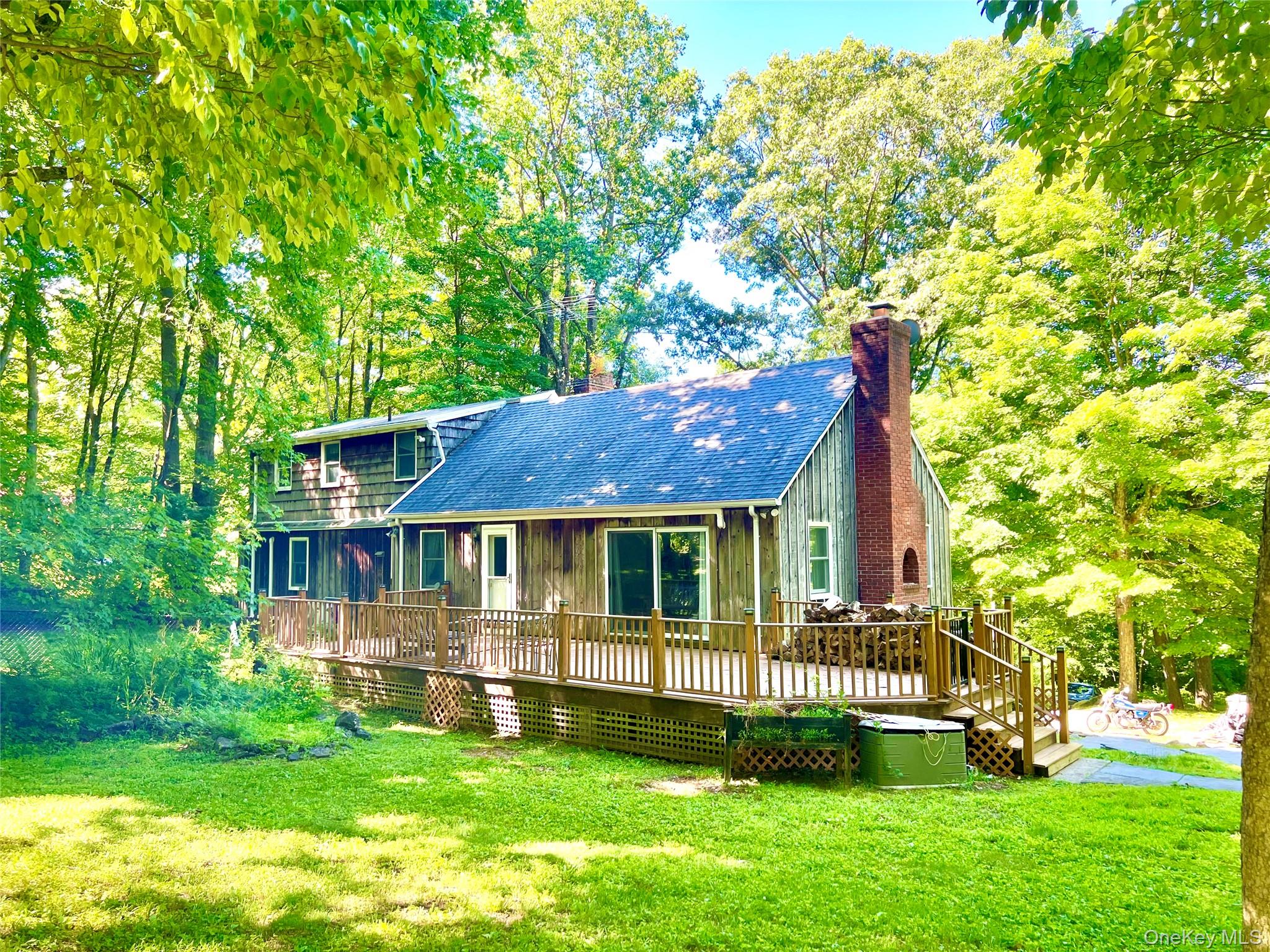 This lake community home has deeded access to Truesdale Lake and is located in the award-winning Katonah-Lewisboro School District.  Located on a quiet cul-de-sac, this expanded cape cod-style home has good bones and great potential.  Upon entering, a fireplace warms the front parlor and living room.  Beyond, the kitchen opens to a dining room and an expanded family room with a stone fireplace, home office/den, and a large outdoor deck, forming the hub of this four-bedroom home.  There are two bedrooms upstairs and two down, with a full bathroom on each floor.  Extra storage is available in an attic easily accessible from the second floor as well as in a large unfinished basement.  The level backyard includes a fenced area, old stone walls, mature trees, a concrete pad/patio with a basketball hoop, and plenty of room for a garden.
