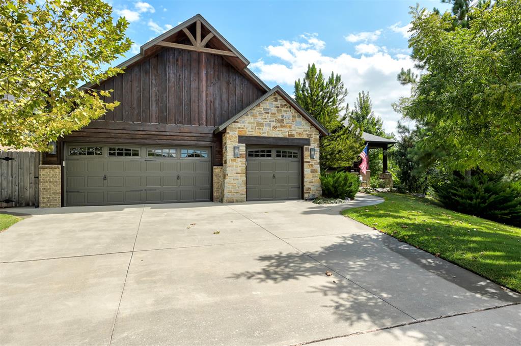 Welcome to this private retreat in the desired community of Cottage Grove, where custom craftsmanship & elevated design come together in perfect harmony. From the moment you enter this home, the richly stained wood accents & thoughtfully curated finishes set the tone for a home that is both warm & refined. The spacious living room features a beautiful stone fireplace with accent wood that carries your eyes up to the ceiling, where bold exposed beams create a striking architectural centerpiece. The kitchen has stunning custom cabinetry, a statement black hutch with purposeful storage, double islands with contrasting butcher block & a solid slab of beautiful granite that is both eye-catching & functional. The glass backsplash with pot-filler adds a great chef's touch for cooking on your Wolf Range. A private downstairs study with elegant French doors offers the perfect work-from-home retreat. The stunning primary suite is a true sanctuary, complete with a spa-like bathroom featuring a walk-in shower with river stone tile, his-and-hers vanities, and a luxurious soaker tub. & natural light filtered through classic plantation shutters. This home offers four additional secondary bedrooms with spacious closet space and plenty of room for family members or guests. Upstairs is a spacious bonus room, making it a great flex space for anyone's needs, two secondary bedrooms & a full bathroom, making it convenient for all. Throughout the home, the lighting design is as intentional as it is beautiful--from the statement pendant lights to designer ceiling fans, every detail speaks to elevated taste. This home backs up to a wooded greenbelt with captivating forest views, a private oasis. Enjoy the view from either your covered patio or the extended Trex deck built to support a swim spa/hot tub. An attached insulated shed and fire pit are an added bonus. This home is perfect for entertaining family & friends, stargazing, gardening & nature lovers, make it yours today!
