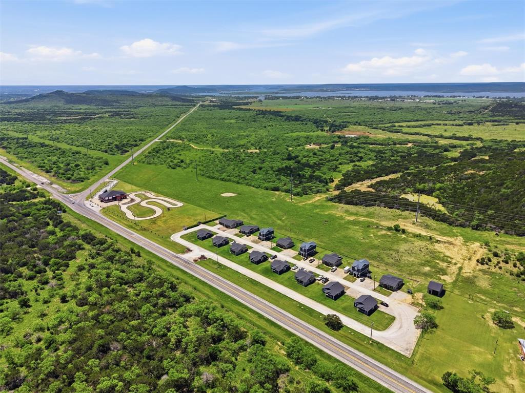 Exceptional commercial and investment opportunity just minutes from Possum Kingdom Lake. Situated on 6.586 acres with prime Highway 180 frontage, this unique property offers unmatched visibility, strong traffic counts, and endless potential for future development or continued income production.The property consists of two parcels and currently features 16 rental cabins being utilized as long-term rentals. Of the 16 cabins, 13 offer 2 bedrooms and 1 bath, 2 offer 3 bedrooms and 2 baths, and 1 offers 1 bedroom and 1 bath — creating a diverse rental mix with established income potential.In addition to the residential component, the property also includes an impressive 5,500 square foot commercial building formerly operated as an arcade and race track facility. With its strategic location, highway exposure, and ample acreage, the commercial possibilities are truly endless — ideal for entertainment, retail, restaurant, event venue, storage, redevelopment, or expanded hospitality use.Rarely does an opportunity with this level of versatility, acreage, income potential, and premier location near Possum Kingdom Lake come available. Whether you are an investor, developer, or entrepreneur, this property is positioned for exceptional future upside.
