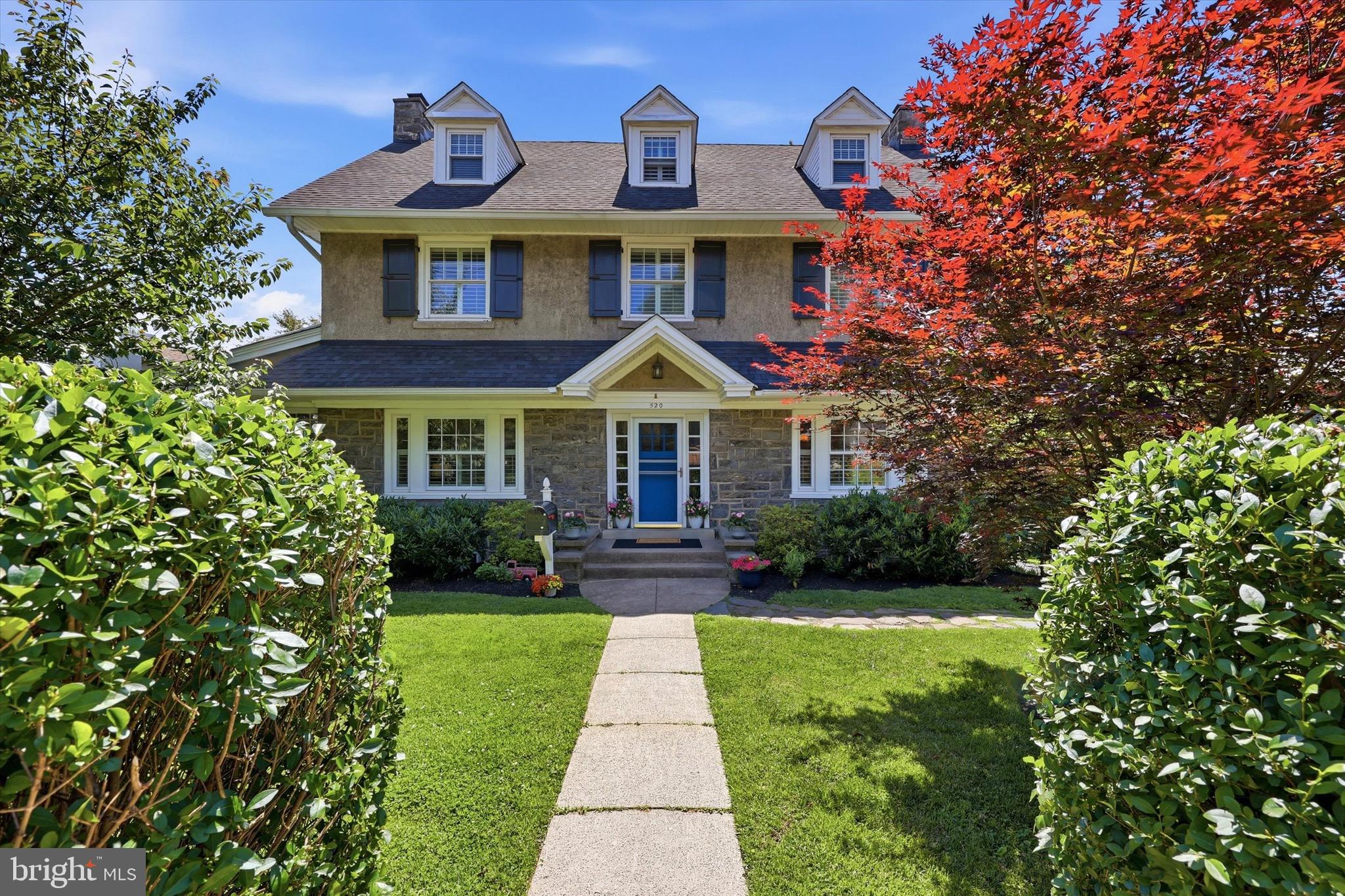 Welcome to 520 North Essex Avenue, a substantial and beautifully timeless detached Center Hall Colonial that offers something nearly impossible to find in the Borough: true breathing room. Situated on an incredibly rare, nearly 1/3-acre lot, this 5-to-6-bedroom home effortlessly combines classic Main Line architectural character with a sprawling outdoor footprint and an unmatched walkable lifestyle.Step past the lovely landscaping and deep front yard and inside to a main level defined by generous proportions, symmetrical design, and beautiful natural light. Enter into the welcoming foyer, where you'll immediately notice the gleaming hardwood floors and custom plantation shutters exuding casual elegance. The sprawling formal living room invites you to gather around the cozy gas fireplace, while the large formal dining room on the opposite side of the foyer is perfectly scaled for hosting large family dinners and casual get-togethers. The heart of the home features an upgraded kitchen, styled with white cabinets, gray quartz countertops, a microwave drawer, and a modern appliance package fully equipped for daily meal prep and weekend entertaining alike. Just beyond the kitchen, a convenient main-floor powder room and dedicated laundry area lead out to a rear porch. Off the main living space, a gorgeous, all-season sunroom serves as the perfect spot for a bright home office, a quiet reading nook, or a main-floor playroom.The upper levels are intelligently designed to offer both generous space and flexible living solutions. The second floor features a wonderful Primary Suite layout. This impressive arrangement combines a king-sized main bedroom with an attached private sitting room and dressing area featuring a walk-in closet and its own convenient en-suite half-bath. Two additional bright bedrooms and a full center-hall bath complete this level, along with access to a private walk-out deck equipped with a retractable awning—an elevated outdoor retreat in the tree tops looking out over the large yard. Ascend to the third floor to find a quiet escape featuring two additional spacious bedrooms with side storage closets and a second upgraded full hall bath, serving as an exceptional space for a long-term guest wing, private home office, or a dedicated au pair suite. Downstairs, the large unfinished basement offers great clean storage area.But the real showstopper is the backyard—and it starts before you even get there. A long, private multi-car driveway runs alongside the home, an almost unheard-of luxury in the Borough where on-street parking is the norm. Fully fenced-in, exceptionally private, and massive by Narberth standards, the backyard itself is a professionally landscaped green space and a tranquil oasis for play, pets, and premier outdoor living. Nestled in the back right corner is a detached garage equipped with electrical wiring. Whether you dream of a detached workshop, a creative studio, or the ultimate staging ground for festive garden gatherings under the installed outdoor lights, this space delivers.  Truly a wonderful home.