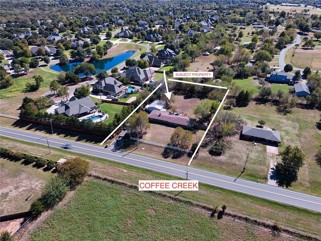 LOCATION, PRIVACY, HUGE SHOP & NO HOA in the HEART OF EDMOND! Tucked away on just over an acre right off Coffee Creek Rd in the highly sought-after Edmond North school district, this property is a rare find offering mature trees, incredible privacy and room to spread out while still being close to everything Edmond has to offer! This remodeled 2,115 sq ft home features 3 bedrooms, 2 full baths PLUS a versatile bonus room that could easily serve as a 4th bedroom, home office, guest suite or apartment-style space. Inside, you’ll find LVT flooring, fresh interior paint, updated lighting and replaced windows throughout. The updated kitchen features granite countertops, updated cabinetry, hardware and stainless appliances. Both bathrooms have been beautifully updated, including vanities, fixtures and showers, with an upgraded tiled shower in the primary suite. A spacious den with exposed cedar beams and a wood-burning fireplace creates a warm second living area. The bonus room also provides access to the basement—perfect for storage or a storm shelter. Outside is where this property REALLY stands apart! The fully fenced acreage is surrounded by mature trees and professional landscaping, creating the ultimate private backyard oasis. Enjoy an oversized covered patio, 200+ sq ft pergola, TIKI BAR, hot tub and raised garden beds. The HUGE 1,200 sq ft SHOP features steel-beam construction, concrete floors, insulated ceiling, fluorescent lighting and a partially started office/bathroom area ready to customize. Additional features include extra asphalt parking, private well with NO WATER BILL, owned water softener and aerobic system. Acreage, privacy, shop space and NO HOA—all in the heart of Edmond!