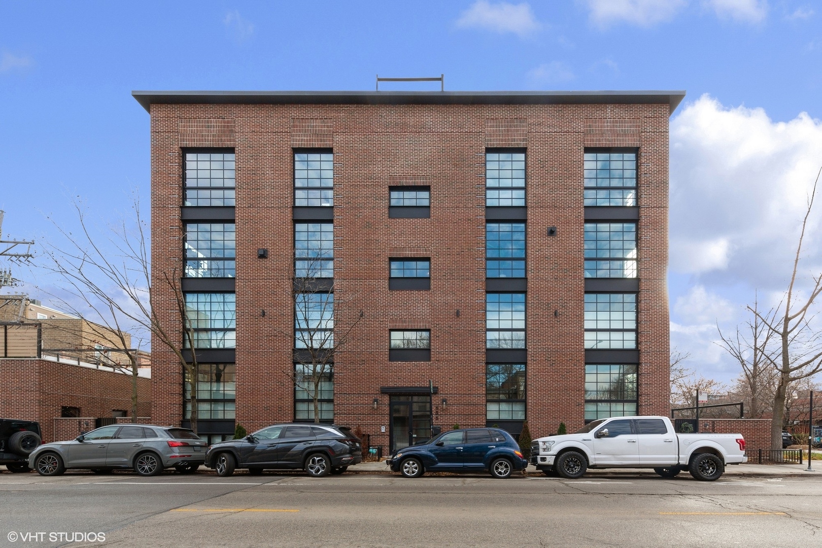 Experience elevated city living in this sophisticated corner duplex-up featuring 3 bedrooms and 2.1 bathrooms, thoughtfully designed with premium materials and high-end finishes inspired by Chicago's Industrial Revolution. Built by Halcyon Development, this residence offers an open and airy living and dining area highlighted by floor-to-ceiling windows that flood the space with natural light. The chef's kitchen is beautifully positioned at the heart of the main level, showcasing a striking waterfall island, professional-grade appliances, custom cabinetry, and designer lighting by Lightology. Just off the main living space, enjoy a private terrace, perfect for relaxing or entertaining. All three bedrooms are located on the upper level, including a spacious suite overlooking Armitage Avenue. The en-suite bath features a large black metal-framed glass shower, marble tile, dual vanity with designer lighting, and heated floors for added comfort. Additional features include white oak hardwood flooring, detailed millwork with crown molding and raised baseboards, generous closet space, and a stylish navy wet bar on the third level that opens to a fully built-out roof deck boasting breathtaking 360-degree skyline views, outdoor kitchen with built-in grill, & beverage cooler. One garage parking space is included. Ideally located with easy access to dining, shopping, and transportation, this home offers exceptional style and convenience.