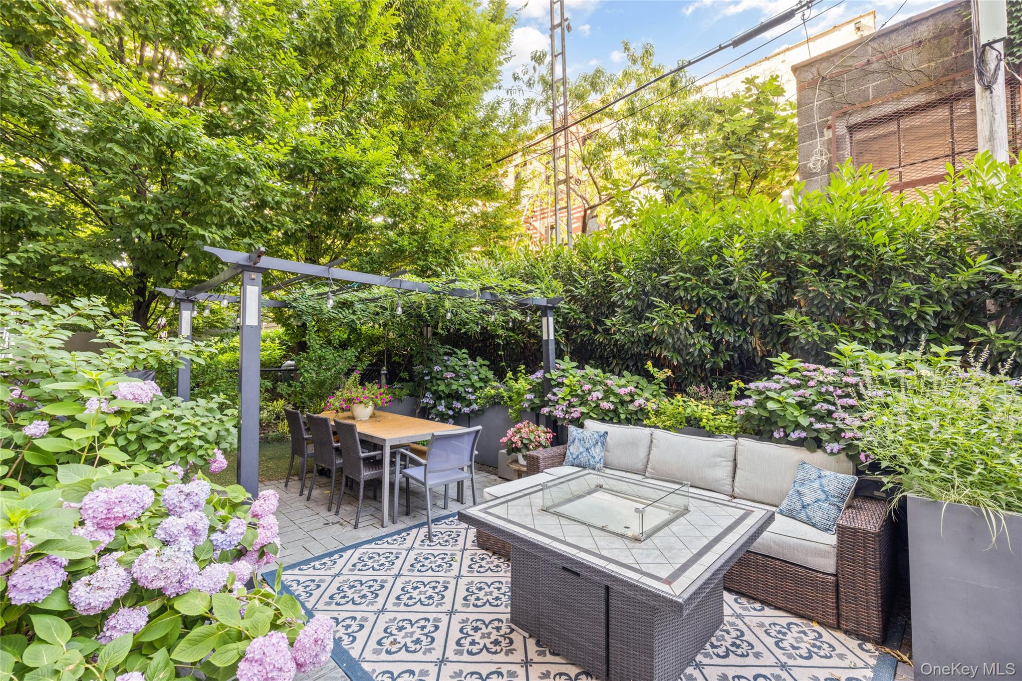 Rent to Own is an option for this beautiful property. A truly one-of-a-kind private outdoor oasis awaits at One Hunters Point, one of Long Island City's most desirable and conveniently located condominium residences. Beautifully renovated from top to bottom, this exceptional 2BR/2BA home pairs sophisticated interior finishes with an extraordinary 1,900+ square feet of private outdoor living-a rarity in New York City. Every detail of Residence 2B was thoughtfully redesigned with luxury and functionality in mind. The custom European lacquer cabinetry, soft-close drawers, and stunning Caesarstone Statuario Maximus quartz waterfall countertops create a sleek, modern kitchen that is as beautiful as it is practical. Premium appliances include a Miele range, as well as Bosch Benchmark refrigerator, dishwasher, and microwave & electric oven combo. The living and entertaining spaces are equally impressive, featuring a fireplace framed by elegant Porcelanosa tile, a custom bar, and a 92-bottle Thermador wine refrigerator. The spacious primary suite is a private retreat, complete with a custom-designed walk-in closet and a spa-inspired bathroom featuring a Steamist steam shower with aromatherapy, Porcelanosa tile, a heated towel warmer, and a Toto Washlet. The second bathroom offers its own luxurious escape with a Kohler air tub, while the generously-sized second bedroom also features custom-built closets. Throughout the home, Canadian-imported maple hardwood floors with an Evershine finish add warmth and elegance, and a full-sized Whirlpool washer/dryer provide everyday convenience. The true showpiece of this remarkable home is its expansive 1,684-square-foot private backyard-an outdoor sanctuary unlike anything else in Long Island City. Thoughtfully landscaped with fully irrigated gardens that bloom from early spring through fall, this magical retreat features a shaded pergola for al fresco dining, an outdoor fireplace, grilling area, playground, and five dedicated storage spaces. Whether enjoying your morning coffee on the private balcony or unwinding with a glass of wine by the fire after dinner, this serene outdoor oasis offers an unparalleled extension of your living space. Completing this exceptional offering is a 218-sq.ft. private rooftop cabana with sweeping south-facing Manhattan skyline views-the perfect setting for grilling, relaxing, entertaining, or watching the city's iconic Fourth of July fireworks. For those seeking even more, the buyer has the opportunity to purchase for an additional cost a deeded parking space in the building. One Hunters Point is a full-service, 12-story glass condominium offering a 24-hr doorperson, fitness center, landscaped courtyard with grilling stations and seating, and a residents' lounge. Just moments from the East River waterfront, residents enjoy easy access to Gantry Plaza State Park, playgrounds, a state-of-the-art library, scenic waterfront promenades, and the NYC Ferry connecting Queens, Brooklyn, and Manhattan. Located just one block from the Vernon Boulevard-Jackson Avenue 7 train station, Midtown Manhattan is only one stop away. This is a rare opportunity to own a meticulously renovated home with one of the largest and most enchanting private outdoor spaces in Long Island City.