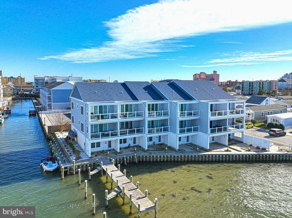 Luxurius 25th St Direct bayfront townhome w/ deeded boat slip now available! Built in 2020 so all major systems & appliances still fresh & gently used. High quality build w/ Batts insulation for quiet living, hardwood, custom tile flooring, architectual doors, Rannai tankless water heater & generous 2+ car garage with extra storage for your cars, toys and boat. Kitchen and bathrooms designed with stylish high end finishes to show off to your friends & family. Both Living room & Primary Suite walk right out to the most incredible decks with bay & sunset views that make you say, "wow, how lucky am I" every single day... All the designer furniture & decor, yup all conveys.. even in all three bedrooms. Walk out back to 100 ft of waterfrontage to the very first slip that will be deeded to you. Lots of extra bulkhead to use for all your other water toys as well.. The Latitudes is even professionally managed, phew! Quaint location close to boardwalk, all the fun bars/restaurants on 28th St., Fishtales. Check out the interactive 3D tour & make your appointment immediately. Units like these do not come up often in this condition!!!