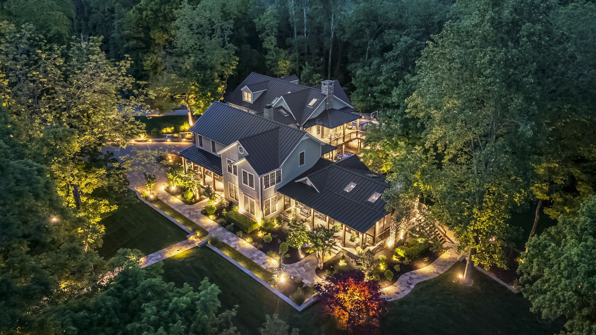 Blending timeless design with premiere modern craftsmanship, this effortlessly luxurious gated property radiates timeless warmth & a sense of home that lingers long after you arrive. On this lush & private haven just under 2 acres, the cares of the day melt away into the gentle sounds of nature. Fully remodeled & extended in 2019, every detail reflects uncompromising dedication to quality. Rich white oak floors stretch beneath solid wood trim & wainscoting while rustic cedar beams soar overhead. Custom walnut mantels sourced from the property are married to locally sourced Tennessee fieldstone crafted fireplaces honoring the land’s historic ties to Brentwood’s early pioneers. It’s the special spaces that make this home unforgettable. An enchanting sunroom, framed by a wall of windows, offers a cozy place to bask in nature’s beauty. Downstairs, a secret pub beckons for lively evenings. In the great room, ceilings soar skyward to form a sanctuary bathed in golden light. With 5 sophisticated suites to choose from, claim your favorite & offer guests equally elevated accommodations each featuring generous walk-in closets & lavish bathrooms appointed with heated flooring & towel bars, threshold-less showers, & designer tile. Enjoy the comfort of discreetly integrated modern systems including Google smart home, EV charging ports, Halo water filtration, & an Air-Conditioned 4 car garage. A sprawling elevated deck wraps around the back of the home encapsulating a central courtyard, offering park-like panoramic views. The spacious screened porch—with a cozy gas-lit wood-burning fireplace & built-in TV cabinetry invites slow mornings. Recreation-ready, the grounds also offer a floodlit play court, a charming playground, a regal stone stairway, a tranquil koi pond, extensive real flagstone stone crafted walkways & a vast lawn perfect for future pool plans. Tucked into a prestigious pocket of Brentwood, this home surrounded by endless acres of woodlands offers true privacy.