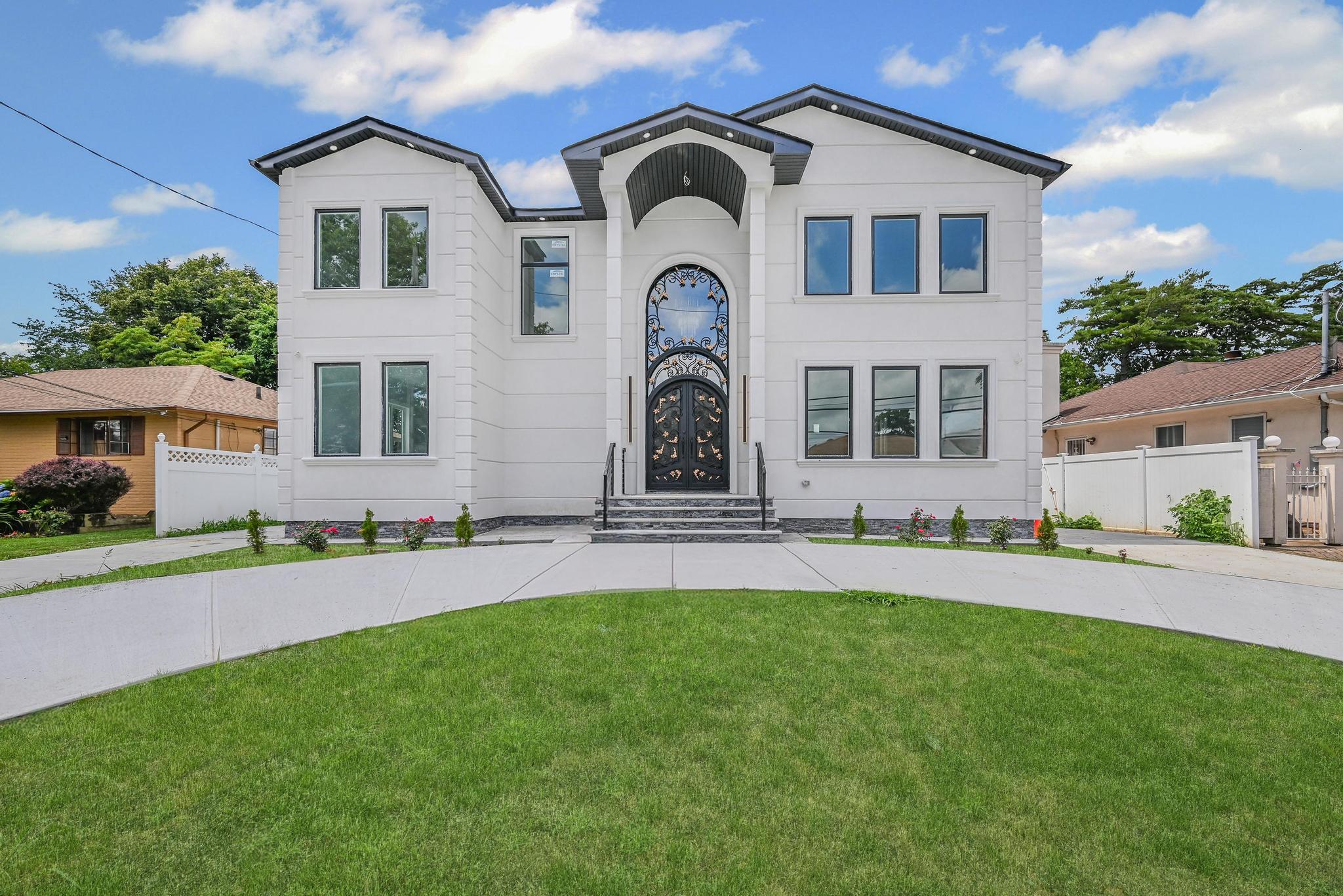 Introducing 892 Barry Drive W, Valley Stream — an exceptional new construction home that blends modern luxury with thoughtful design, situated in a prime Nassau County neighborhood close to schools, shopping, dining, and major transit routes. This elegant residence offers 7 spacious bedrooms and 6 beautifully designed bathrooms across three fully finished levels, providing ample space and comfort for multi-generational living or large families. As you enter through the grand wrought-iron double doors, you’re welcomed into a light-filled open-concept main level adorned with gleaming marble floors, high ceilings, and oversized windows that create a warm and inviting atmosphere. The gourmet kitchen features high-end stainless steel appliances, sleek custom cabinetry, and quartz countertops, seamlessly flowing into the expansive living and dining areas — perfect for both everyday living and entertaining. The first floor includes 2 well-appointed bedrooms, a stylish powder room, and a full modern bath with smart fixtures. Upstairs, discover 7 generously sized bedrooms and 6 luxurious full bathrooms, including multiple en-suites with spa-like finishes, gold accents, and LED-lit mirrors. The fully finished basement, complete with a private entrance and an additional bathroom, offers endless flexibility — ideal for extended family, a guest suite, or potential rental income. Set on a manicured lot with a sweeping circular driveway and striking curb appeal, 892 Barry Drive W is a rare opportunity to own a move-in-ready home that delivers superior quality, modern amenities, and timeless elegance in one of Long Island’s most desirable communities.