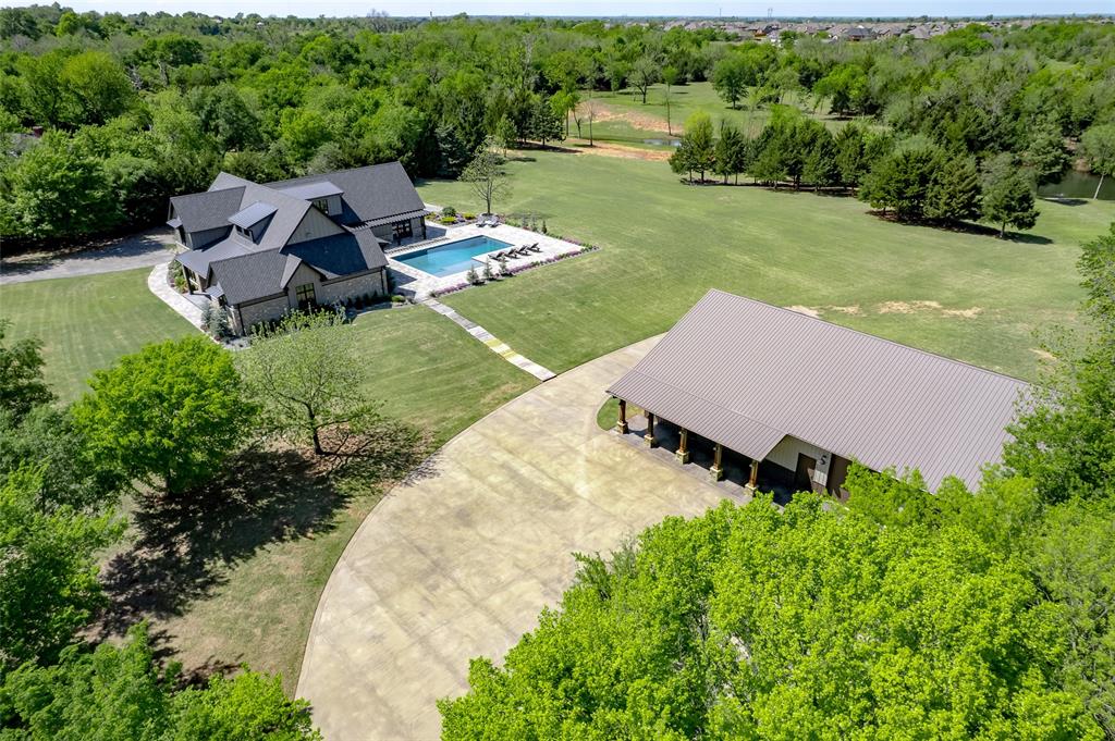 This one-of-a-kind custom home offers almost 4000 square feet of immaculately maintained living space and sits behind gated entries in one of Norman’s fastest-growing areas. Originally built as the homebuilder’s personal residence, the craftsmanship, material selections, and thoughtful design are apparent throughout. This property is located in an unincorporated area of McClain County with no covenants or restrictions—offering both privacy and long-term development potential. Step inside to find a spacious open concept living, kitchen, and dining area perfect for entertaining. The chef’s kitchen features a large island, custom cabinetry, a walk thru pantry which is also the storm shelter, and an adjacent study area ideal for homework or home office use. The layout includes 4 true bedrooms—2 downstairs including a luxurious primary suite with heated bathroom floors and a walk-in closet with one of two laundry areas. Upstairs, you’ll find two more bedrooms, a second laundry area, an additional living space, and a versatile craft room that can easily serve as a 5th bedroom. Above the oversized garage is an additional 480 square feet of insulated, conditioned unfinished space for future expansion. Outdoor features include the pool, beautiful landscaping, stained concrete driveways, large parking areas and expansive patios with picturesque views. This 43 acre property also boasts a fully stocked 7-acre pond, abundant wildlife, and a detached shop with office space and a private gym. The home was built to IBHS fortified high wind standards, Energy Star requirements and has a low HERS rating designation resulting in significant savings on utility bills and homeowners insurance costs. This is more than a home on acreage, it’s a rare opportunity to enjoy peaceful country living close to town, with room to grow and the freedom to create your own legacy.