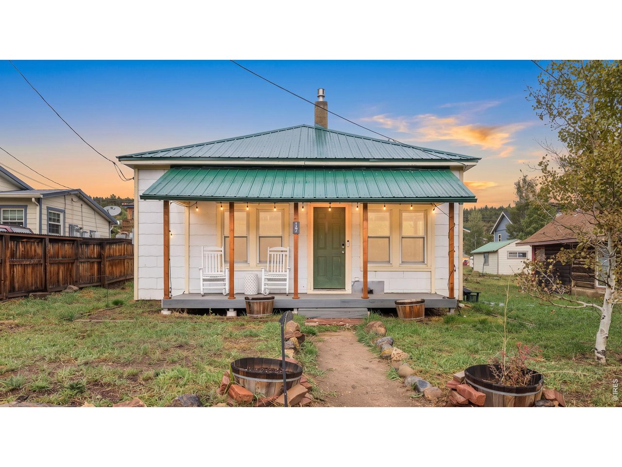 Live in the heart of idyllic Nederland in this charming 100-year-old bungalow, perfectly positioned on a flat double lot along one of town's main streets. Offering the best of mountain-town living, this single-story home is just a short stroll from restaurants, shops, grocery stores, live music, public transportation and Barker Reservoir, with easy access to nearby trails and just minutes from Eldora Ski Resort. A covered front porch welcomes you into a home filled with vintage character and mountain ambiance, with hardwood floors and an inviting open flow between the living and dining areas. A gas fireplace and wood stove add warmth and supplemental heat, while updated fixtures and thoughtful improvements provide modern convenience. The kitchen has been partially updated with newer cabinetry, stainless steel appliances and updated countertops. Adjacent to the kitchen, the remodeled full bathroom features a tub, while a large pantry and storage area provide valuable utility. Three generous-sized bedrooms provide comfortable space for family, guests or a home office if desired. A covered back porch leads to the fenced backyard, with alley access and an oversized attached 2-car garage that connects conveniently to the kitchen. Major improvements include a newer metal roof, updated windows throughout and an owned 8kW solar system installed in 2025. The flat double lot offers space and versatility rarely found in such a central location. This home retains the character and charm of a century-old Nederland bungalow while offering important modern upgrades and infrastructure. It is not completely turnkey and offers an opportunity for a buyer to add their own finishing touches and build upon the improvements already in place. A unique opportunity to own a piece of Nederland history with an unbeatable downtown location, valuable upgrades and plenty of potential.