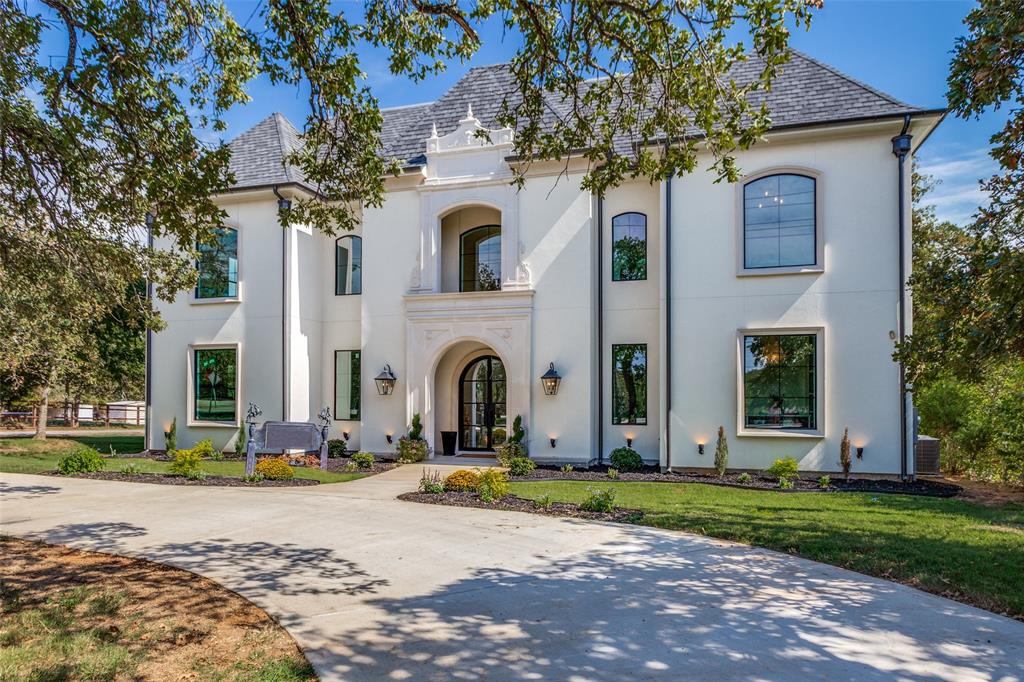 Completed in September 2025 this French inspired custom home blends the perfect balance of modern opulence and luxury living!  As you enter the home through the iron door you are greeted with a double rounded staircase with soaring 24 foot ceiling, impressive chandelier, premium finishes with over $100,000 in lighting, and hand scraped hardwood flooring throughout the first floor. The main living area features an open concept floor plan with wood beam cathedral style ceilings, wall of windows with iron doors to access the backyard, 27 foot tall fireplace and Juliet balconies for added character and design. The professionally designed kitchen features Marble countertops, massive center island, two tone Z-line designer appliances with 8 burner gas range and separate baker pantry with separate oven. Luxury primary retreat is tucked away at the back of the home with double door entry, vaulted ceilings, fireplace, separate entry to private patio, and luxury bath that creates an experience like no other with double vanities, marble countertops, center chandelier, soaking tub & luxury shower! The second floor splits at the top of the balcony to separate a guest suite and the most perfect wing for children, featuring two bedrooms and two bathrooms with a two story game room or play room that is a perfect family oasis. The third floor boasts a 1200 square foot space perfect for another flex room, and has a slide for kids to enjoy that connects to the 2nd level game room. The backyard features another massive covered porch with outdoor fireplace and views of the private tree line! This home sits on .73 acres corner lot with 3 car garage and no HOA. Additional features include Full Spray foam encapsulation, pre wired for home automation, sprinkler system, Keller ISD, minutes from Hwy 114, I35 and Southlake Town Center!