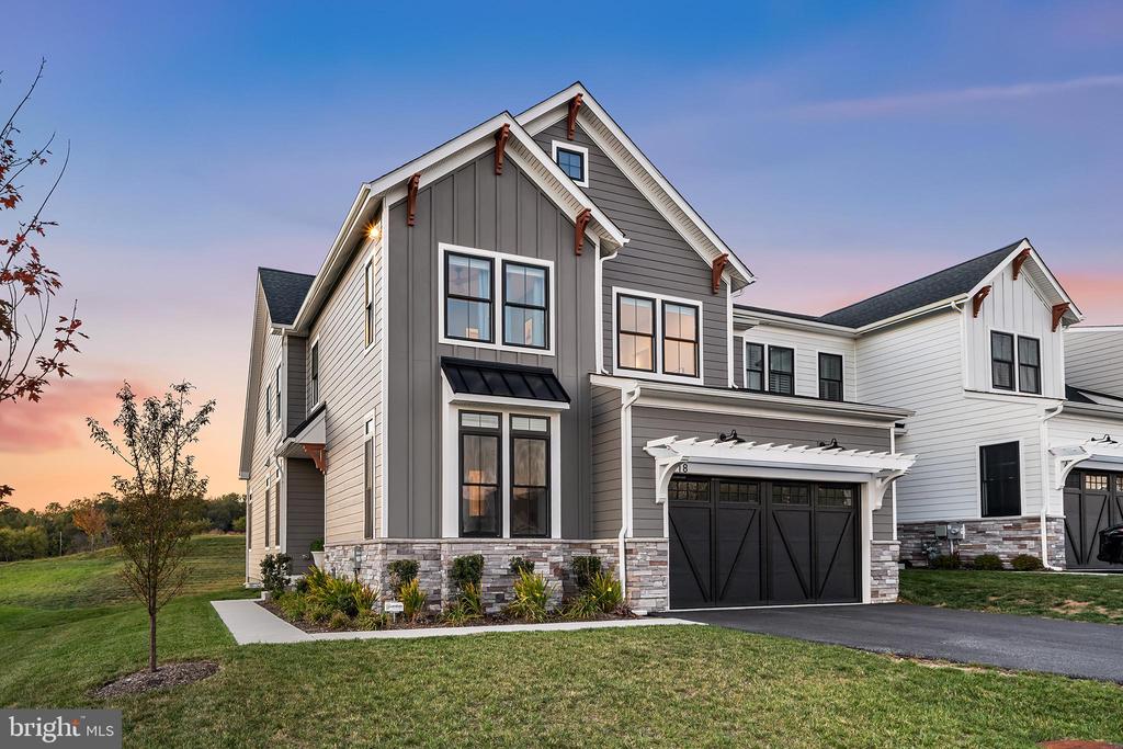 Welcome to 318 Morris Street, an exceptional Rockwell-built end-unit carriage home completed in 2023 and one of the most extensively customized homes in Ventry at Edgmont Preserve. Step into a grand foyer with 10’ ceilings and a light-filled private study just off the entry- ideal for a home office or quiet retreat. The home opens into a stunning open-concept layout, with a light-filled dining room flowing into a dramatic great room featuring vaulted ceilings, custom ceiling millwork, and a gas fireplace.At the heart of the home is a true entertainer’s kitchen- anchored by a 14-foot island with seating for ten, Taj Mahal quartzite countertops, ceiling-height cabinetry, and a walk-in pantry with custom built-ins. A luxury appliance package includes an induction cooktop, warming drawer, pebble ice machine, beverage center, custom range hood, and pot filler- a space built for gathering, hosting, and everyday living at its best. Just beyond, the rear patio overlooks the rolling hills of Edgmont Township and Okehocking Preserve, offering breathtaking sunset views.The main level is completed by a mudroom with custom cubbies, a stylish powder room, and access to a two-car garage with EV charging and ample storage. Upstairs, you’ll find four bedrooms, including a princess suite with ensuite bath, two additional guest rooms, a hall bath, and a thoughtfully designed second-floor laundry room that adds everyday convenience. The primary suite is a serene retreat with vaulted ceilings, a custom walk-in closet, and a spa-like bath featuring marble finishes, penny tile, and a luxurious shower with waterfall shower head. A separate water closet and abundant storage complete this luxury hotel-worthy space. Downstairs, the home continues to impress with a fully finished lower level featuring 9’ ceilings, offering endless flexibility- media room, playroom, gym, entertaining space, or all of the above. A full bathroom and kitchenette/wet bar with the potential for a fifth bedroom with egress make this level as functional as it is beautiful.Ventry at Edgmont Preserve features a wide range of amenities, from nearly two miles of scenic walking trails to a modern clubhouse complete with a fitness center. Residents also enjoy an outdoor pool, tennis and basketball courts, plus dedicated spaces for bocce ball and shuffleboard.With upgraded hardwood flooring, custom staircases, whole-house water filtration, automatic whole-house generator, and countless additional upgrades throughout, this home lives better than new construction in an amenity rich community without the wait, decisions, or compromises.